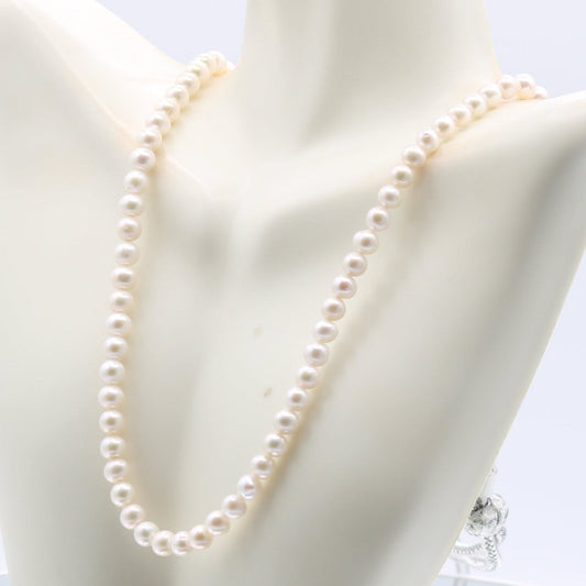 Fresh water pearl necklace displayed on a bust, showcasing its elegant 6mm pearls in a 1-3 strand design.