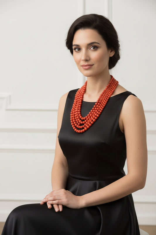Natural Coral Necklace 4-6mm showcasing five strands of vibrant coral beads on a display bust.