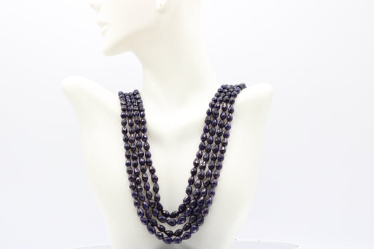 The Blue Sapphire Briolette Pearl Shaped Necklace displayed on a mannequin, showcasing its elegant design and deep blue color.