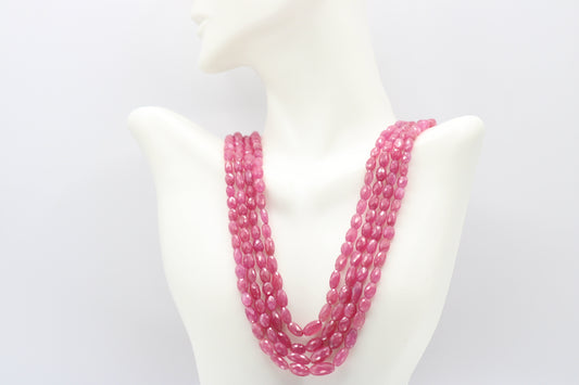 The Pink Sapphire Faceted Necklace displayed elegantly with multiple strands of radiant pink sapphires.
