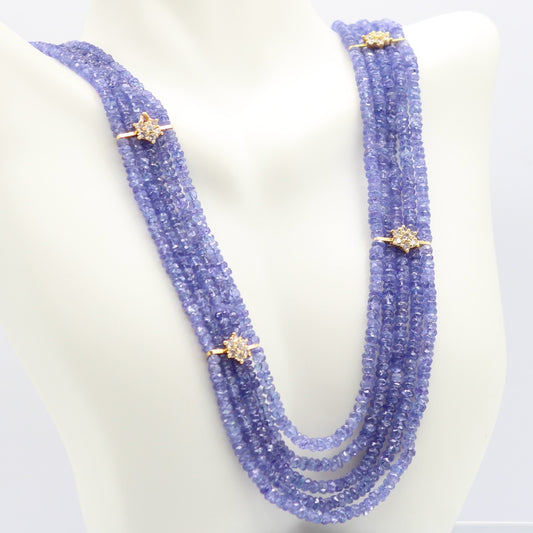 Natural Tanzanite Beaded Necklace featuring blue-violet gemstones with gold accents on a display bust.