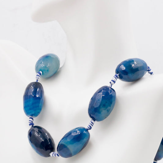 Blue agate beads necklace featuring natural oval gemstones in various shades of blue.