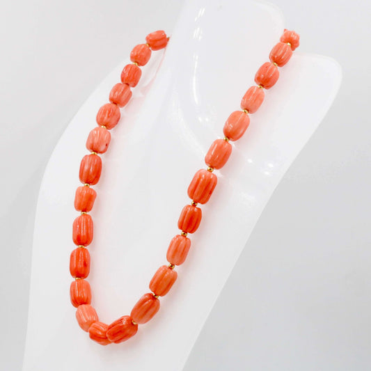 Orange coral necklace featuring beautiful pumpkin-shaped beads on a display mannequin.