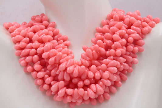 Natural teardrop Coral Bead Strands displayed as a statement necklace, showcasing vibrant coral beads in a teardrop shape.
