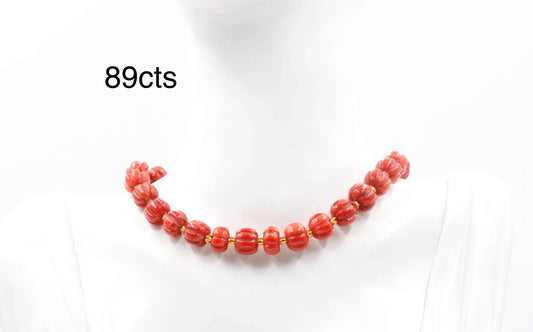 Natural coral pumpkin strand necklace with red coral beads, 89cts, displayed on a mannequin.