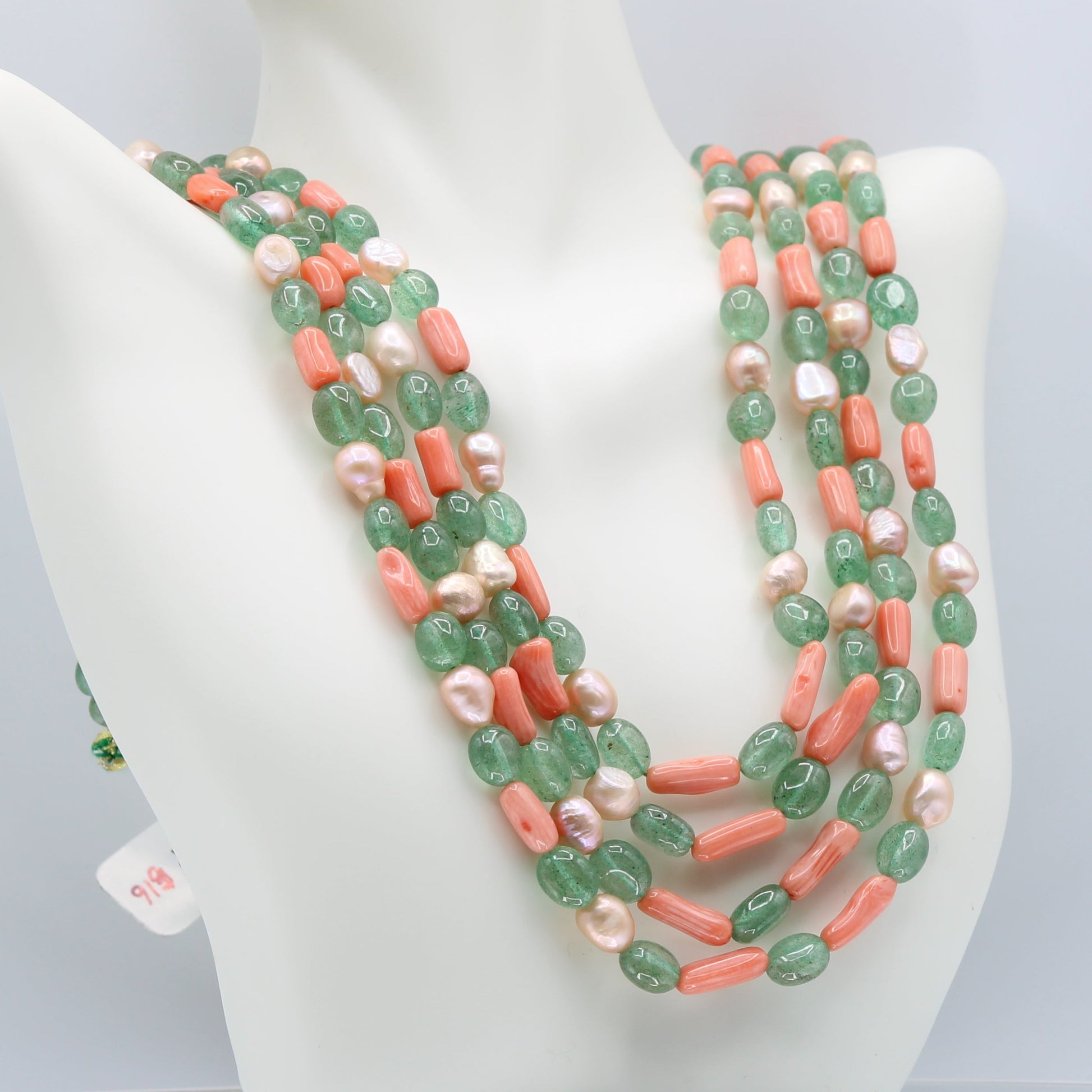 Russian Emerald with FWP and coral layered necklace showcased on a mannequin.