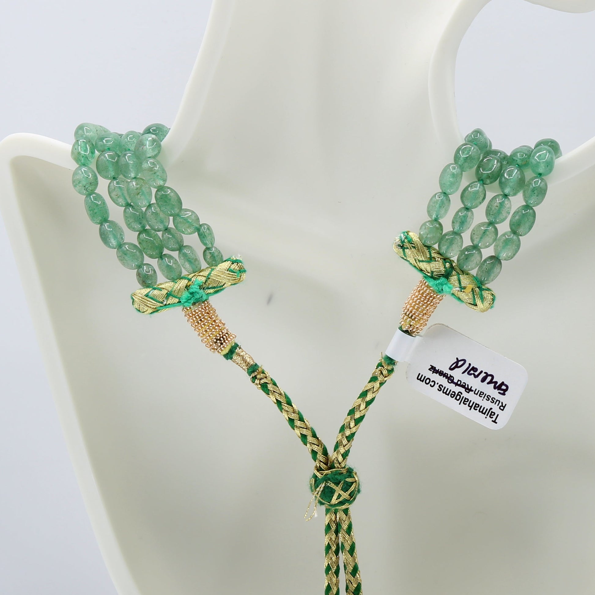 Close-up of a Russian Emerald layered necklace with green beads and decorative clasps.