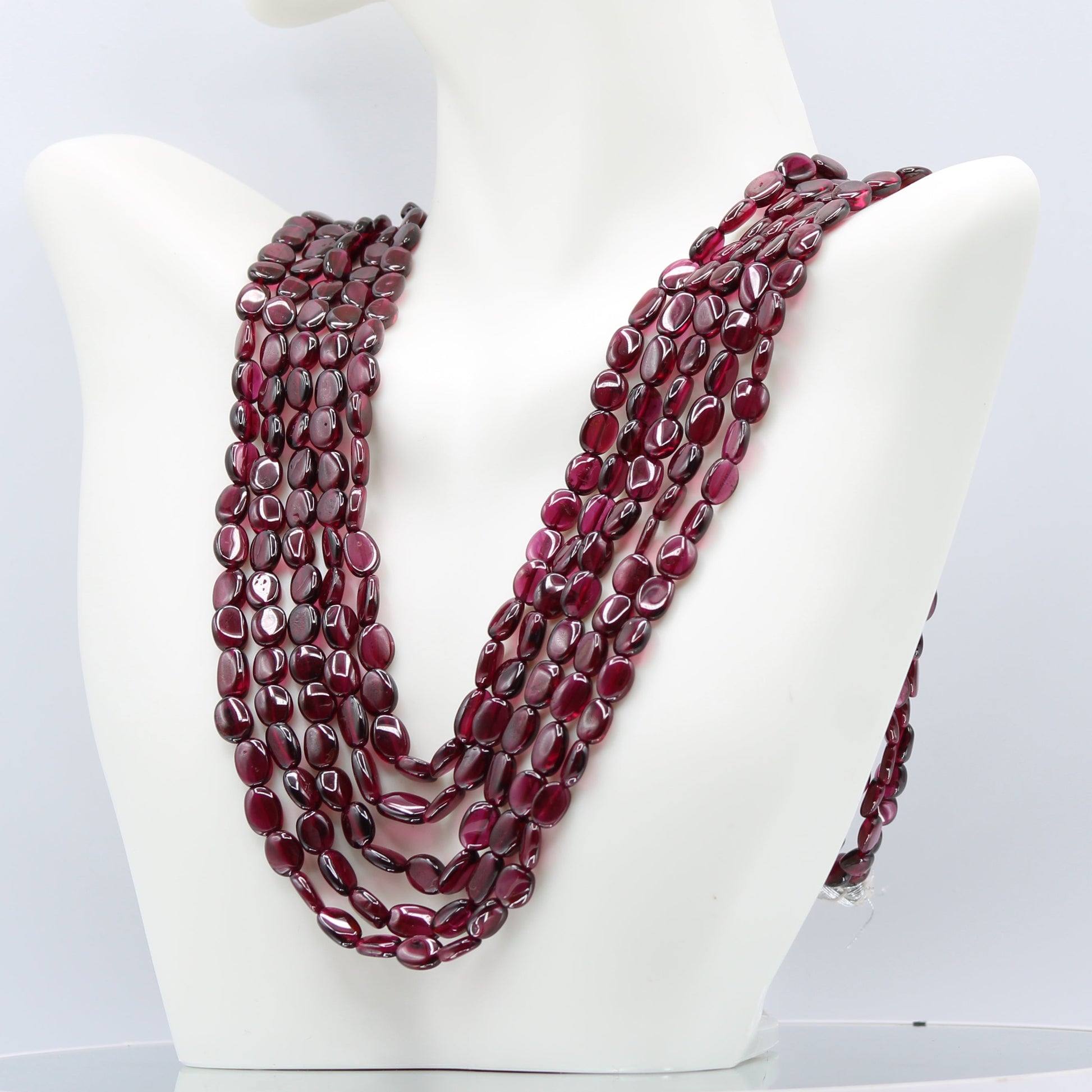 Rhodolite Garnet Smooth Polished Necklace displaying rich rose red hues on a stylish display mannequin.