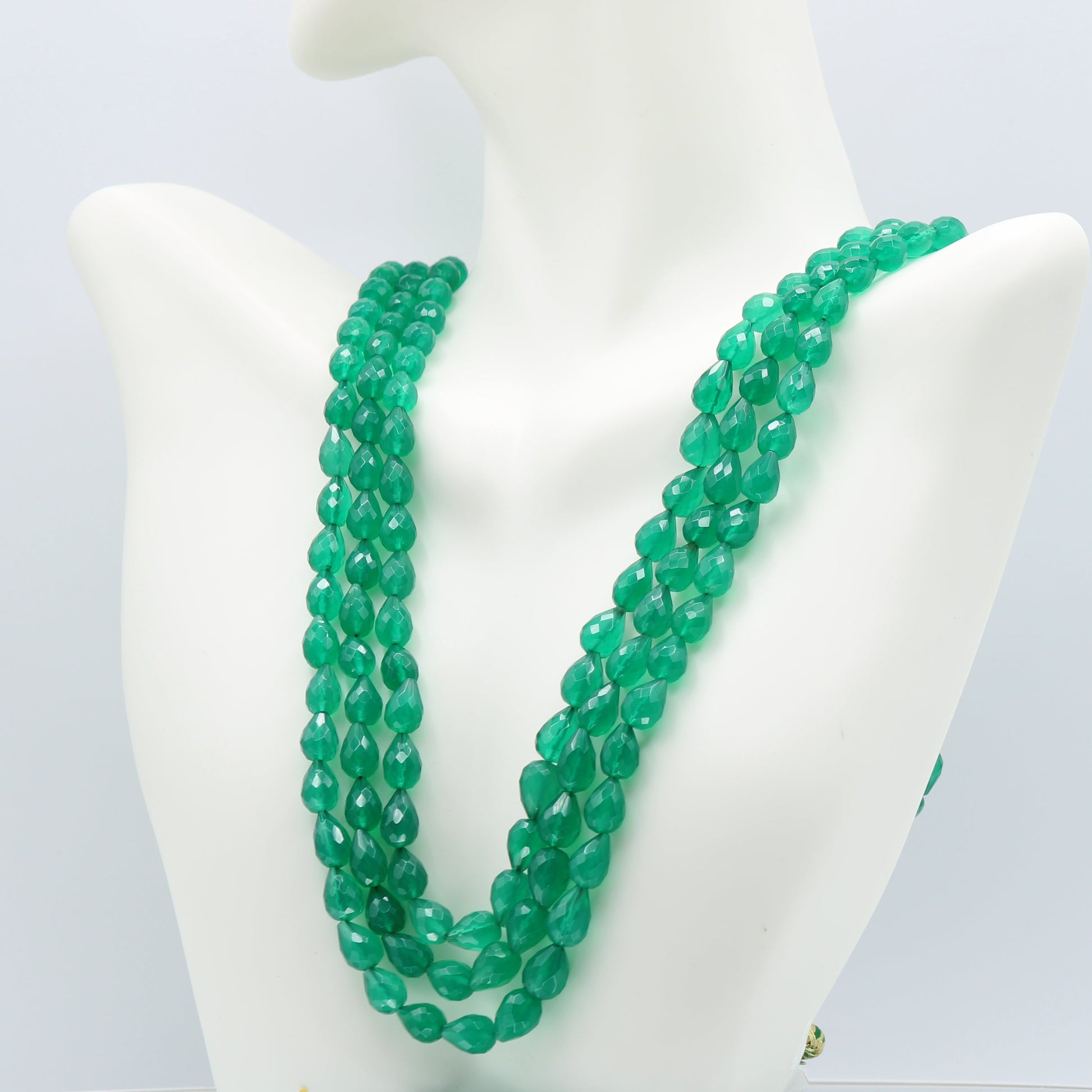 Emerald Pear Shape Faceted Necklace showcasing three strands of green emerald beads on a display bust.