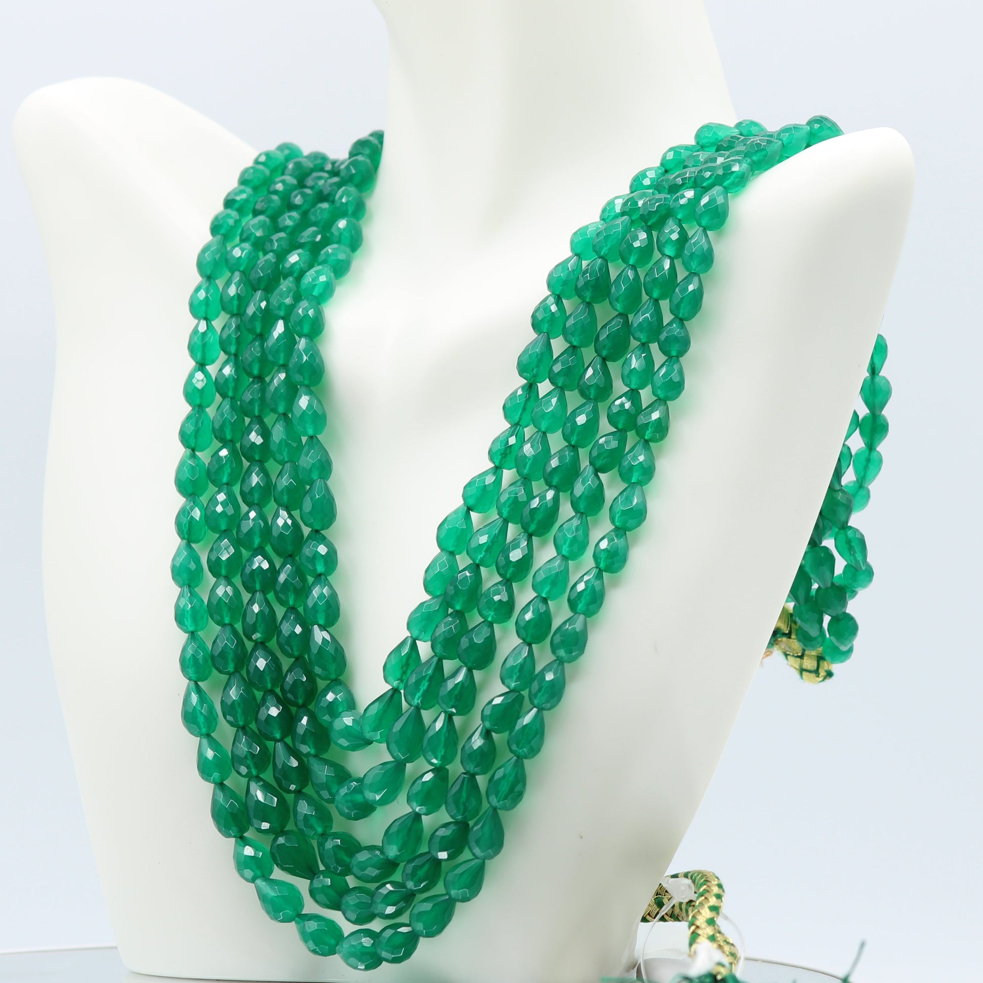 Emerald Pear Shape Faceted Necklace featuring 2, 3, and 5 strands of semi-transparent green emerald beads.
