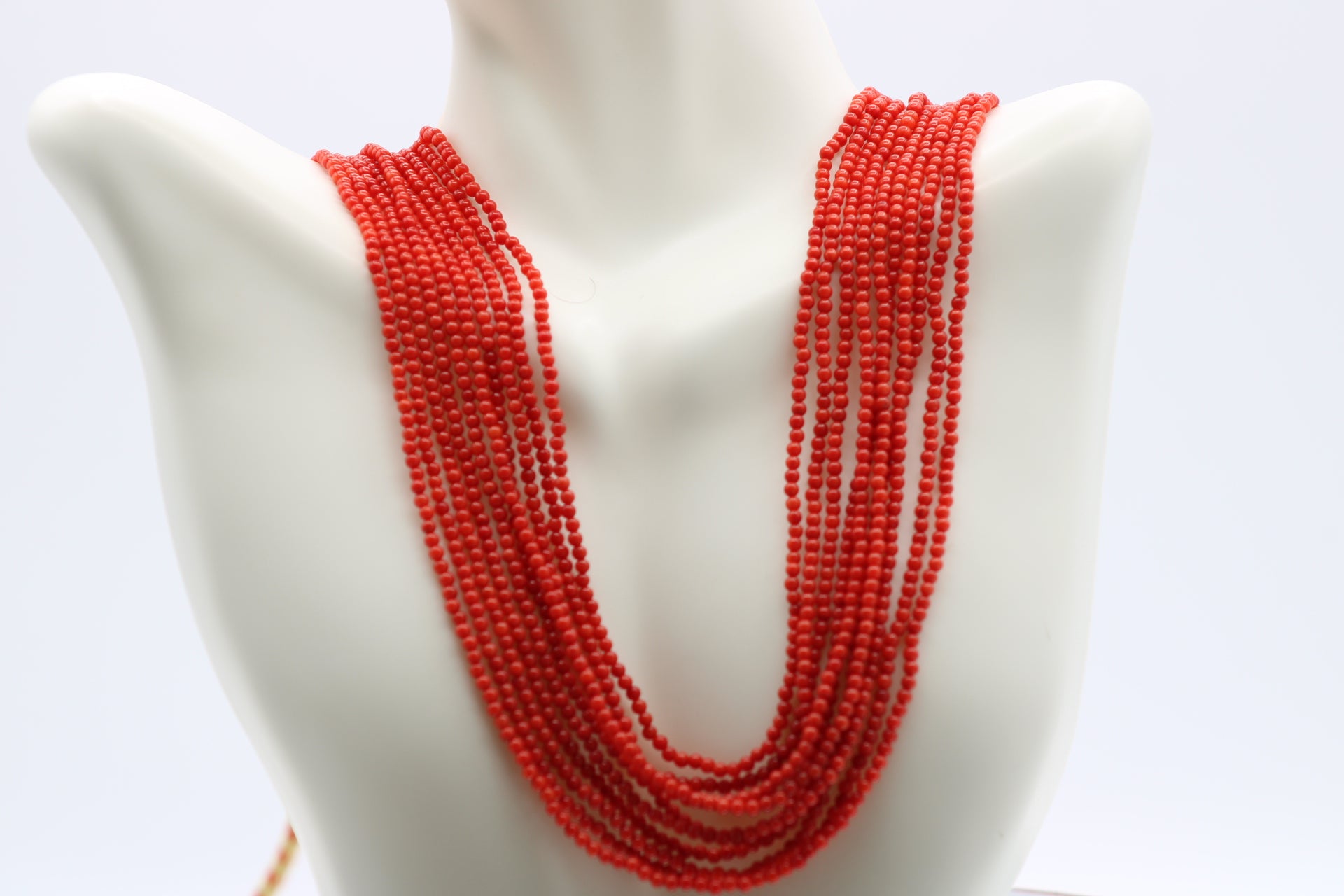Elegant coral necklace 2mm displaying vibrant red coral beads on a mannequin.