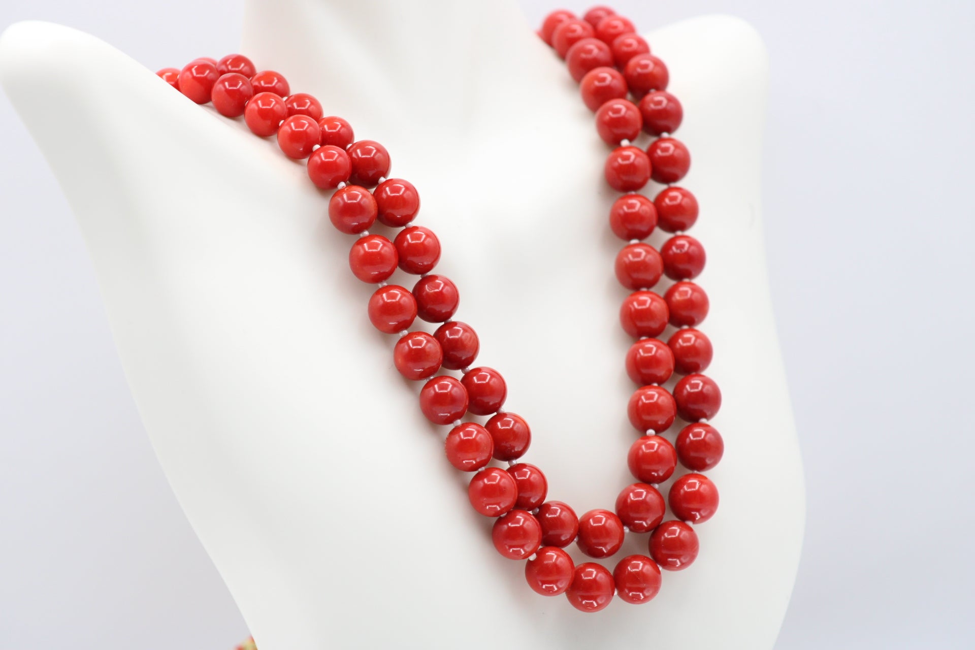 Natural orange coral gemstone necklace 8-10mm displayed on a mannequin with multiple strands.