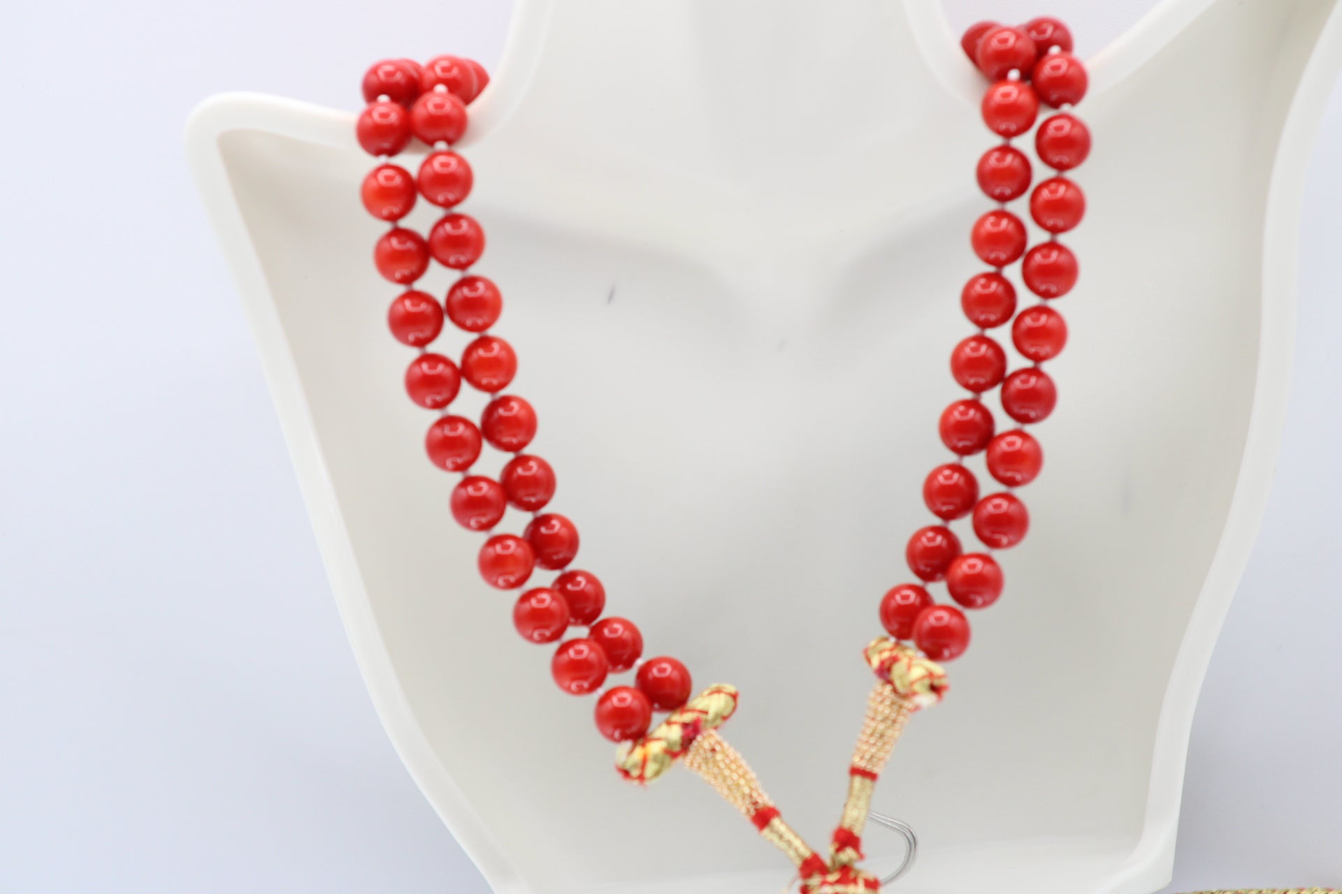 Natural orange coral gemstone necklace 8-10mm displayed on a mannequin with multiple strands.