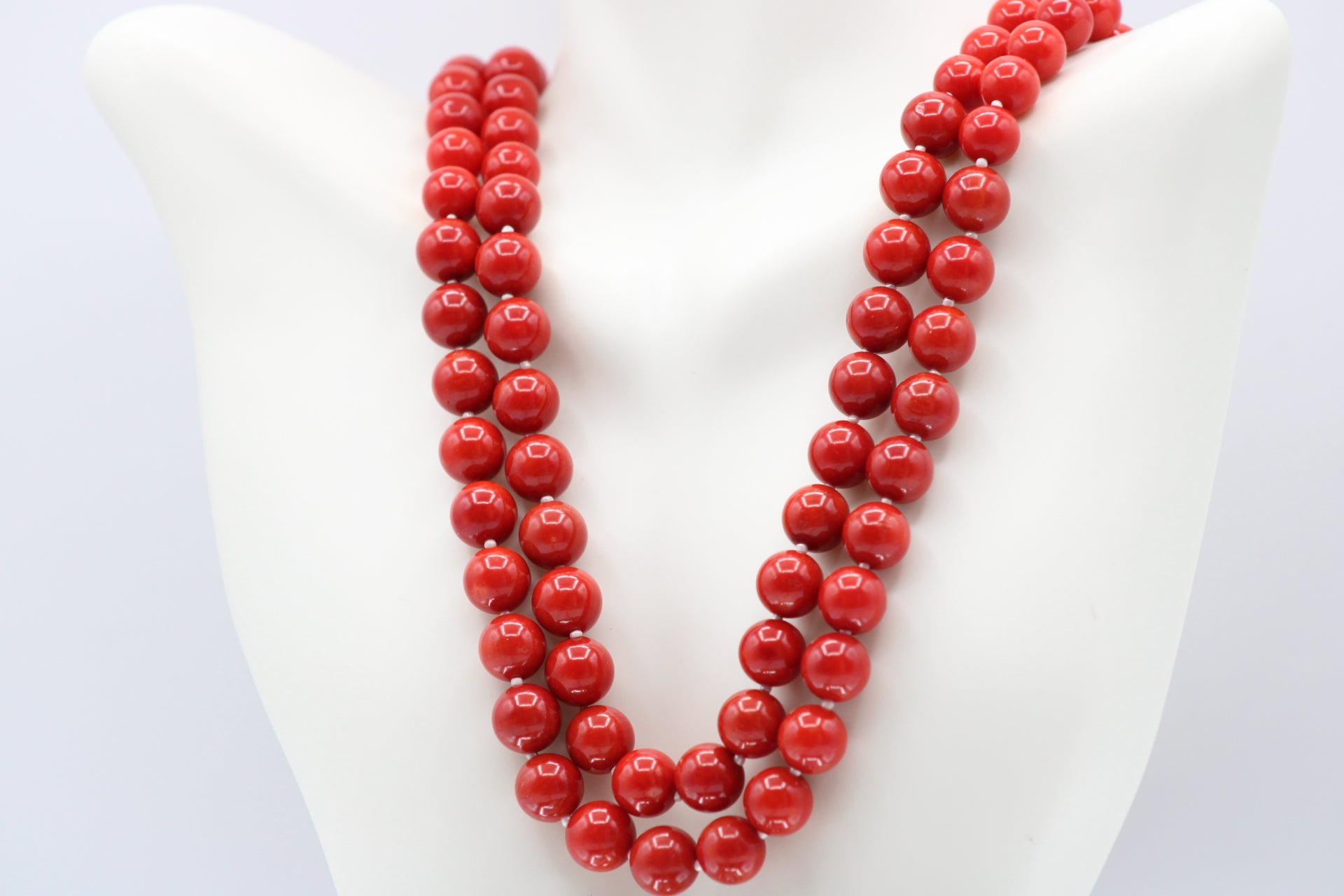 Natural orange coral gemstone necklace 8-10mm displayed on a mannequin with multiple strands.