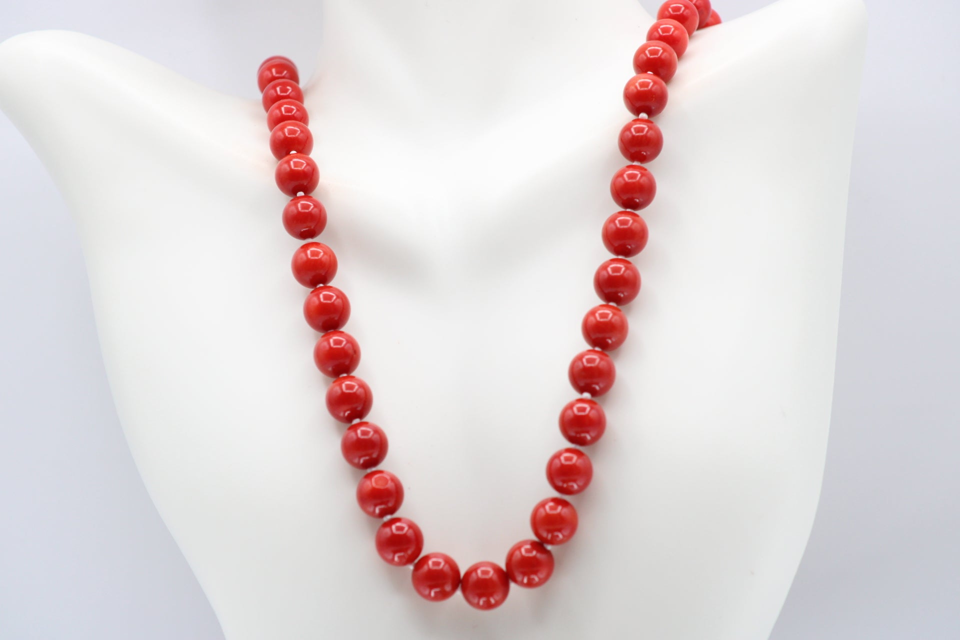 Natural orange coral gemstone necklace 8-10mm displayed on a mannequin with multiple strands.