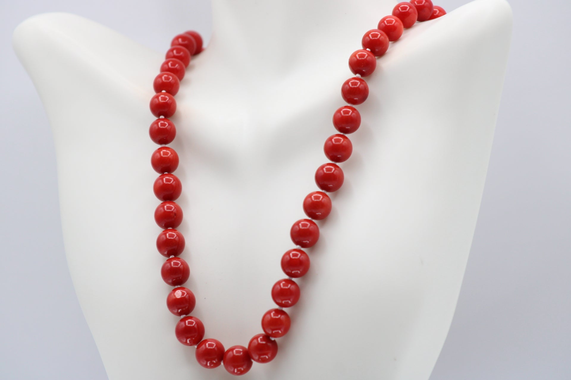 Natural orange coral gemstone necklace 8-10mm displayed on a mannequin with multiple strands.