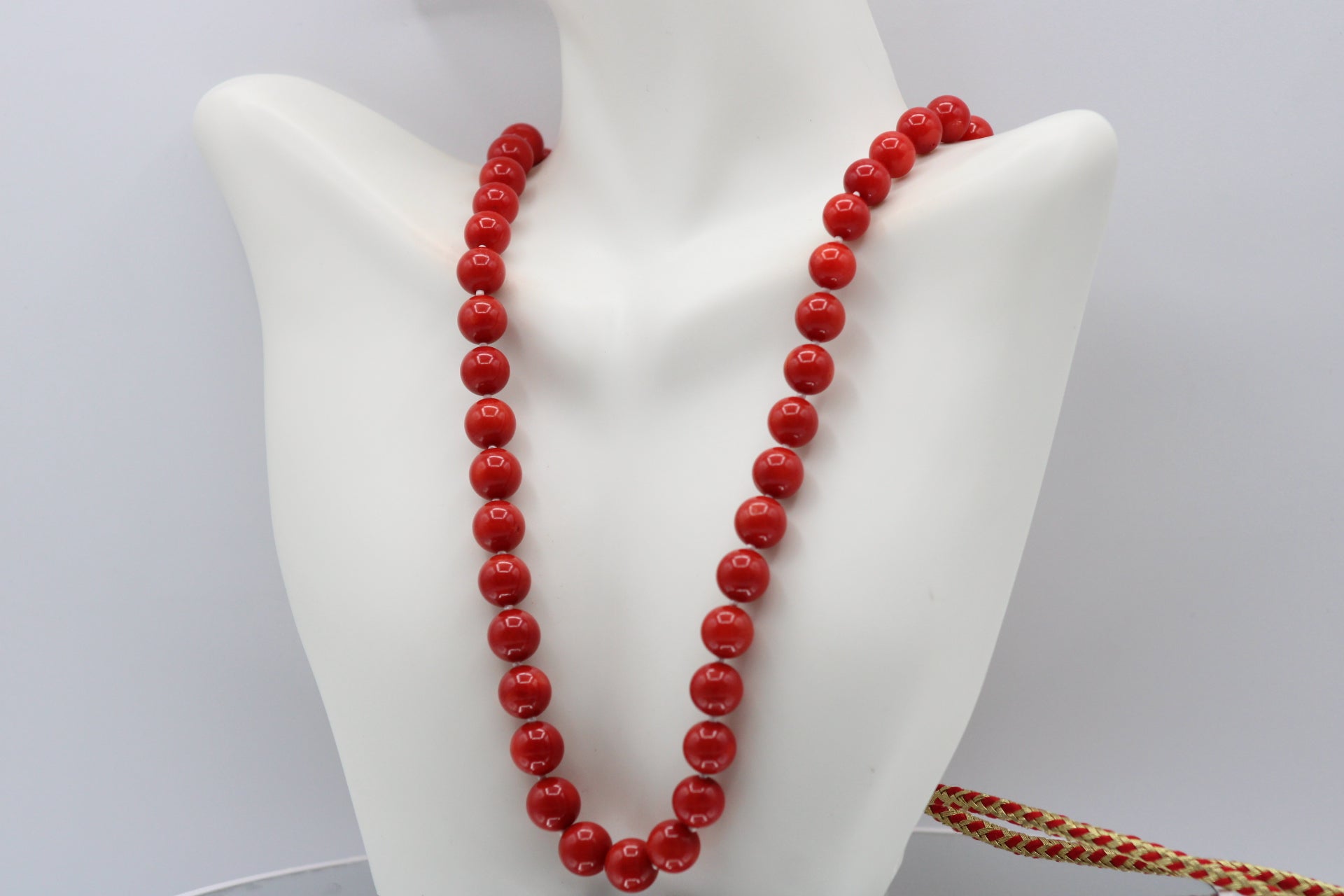Natural orange coral gemstone necklace 8-10mm displayed on a mannequin.