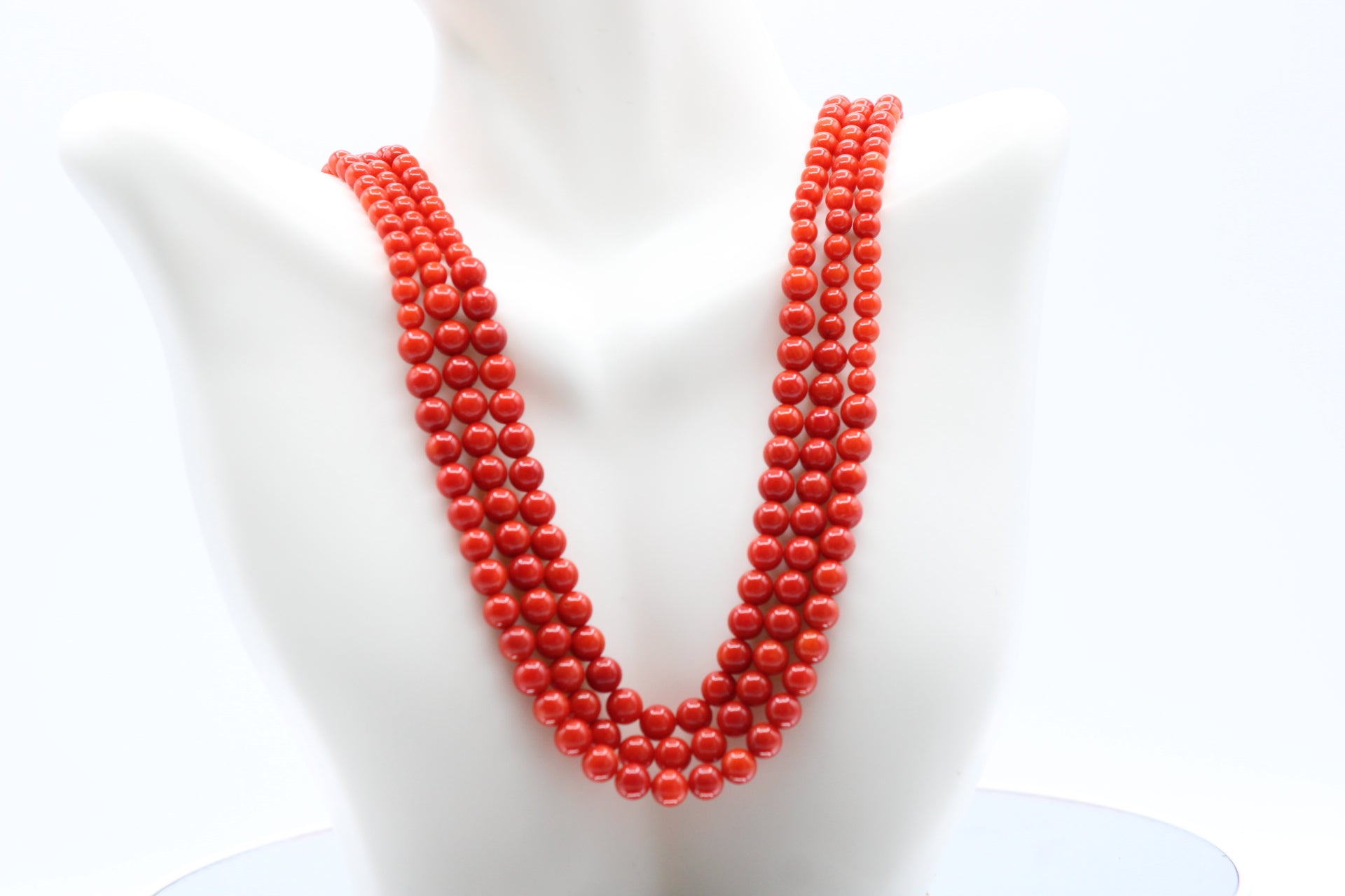 Natural Coral Necklace 4-6mm displayed with five strands of vibrant red coral beads.