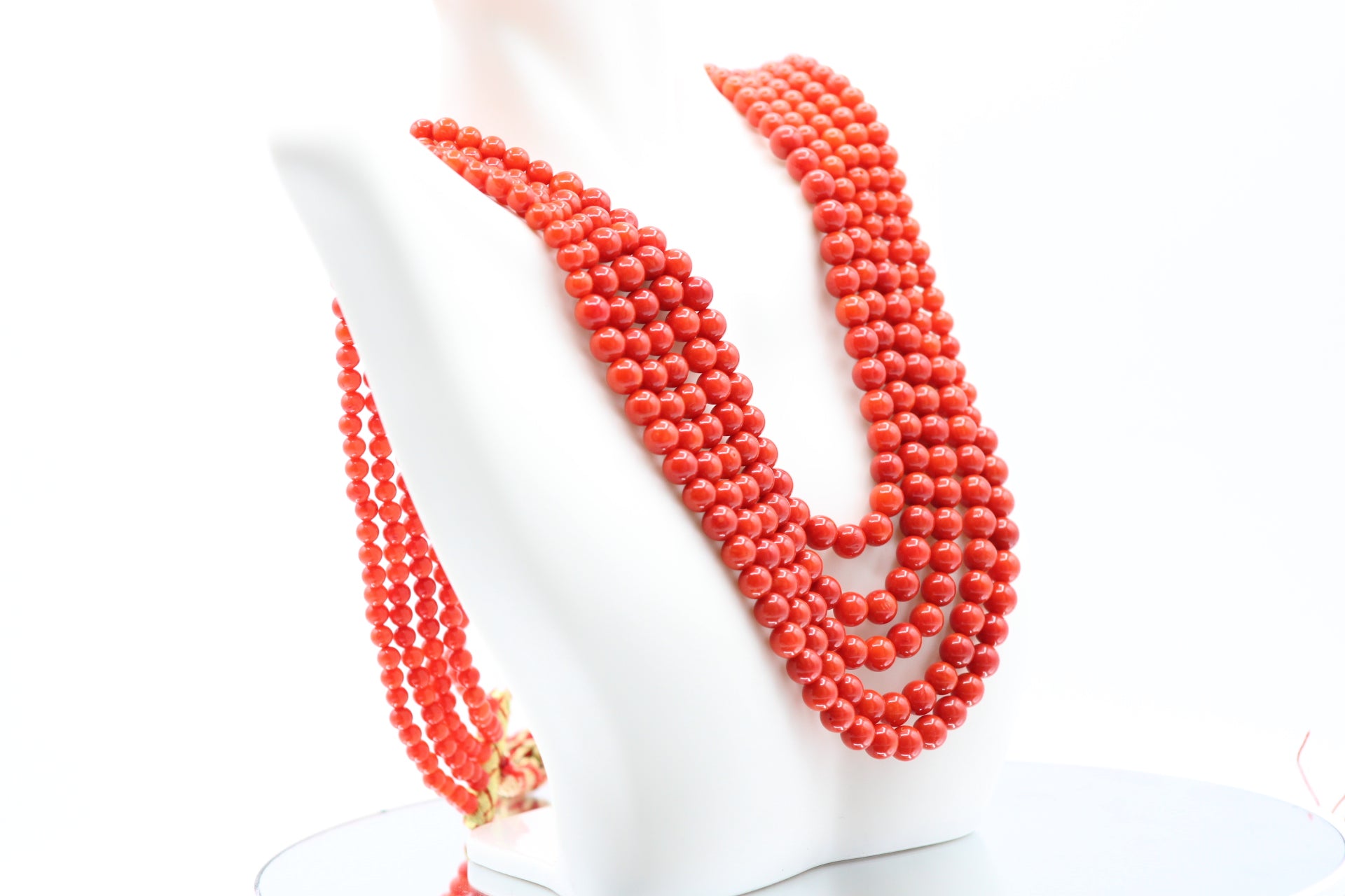 Natural Coral Necklace 4-6mm displayed elegantly in multiple strands on a mannequin.