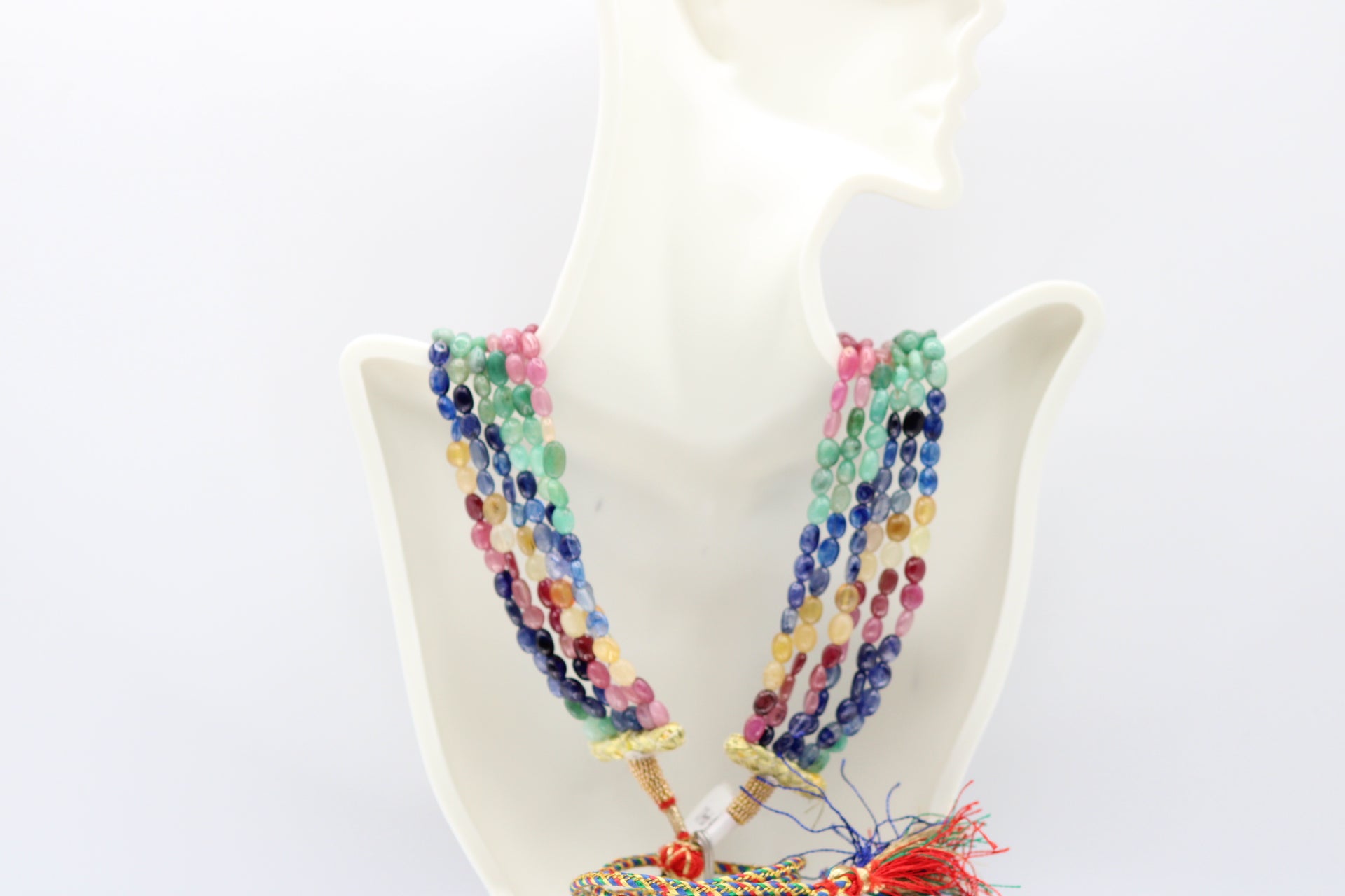 Multi Color Sapphire & Emerald Necklace showcasing vibrant gems on a mannequin display.