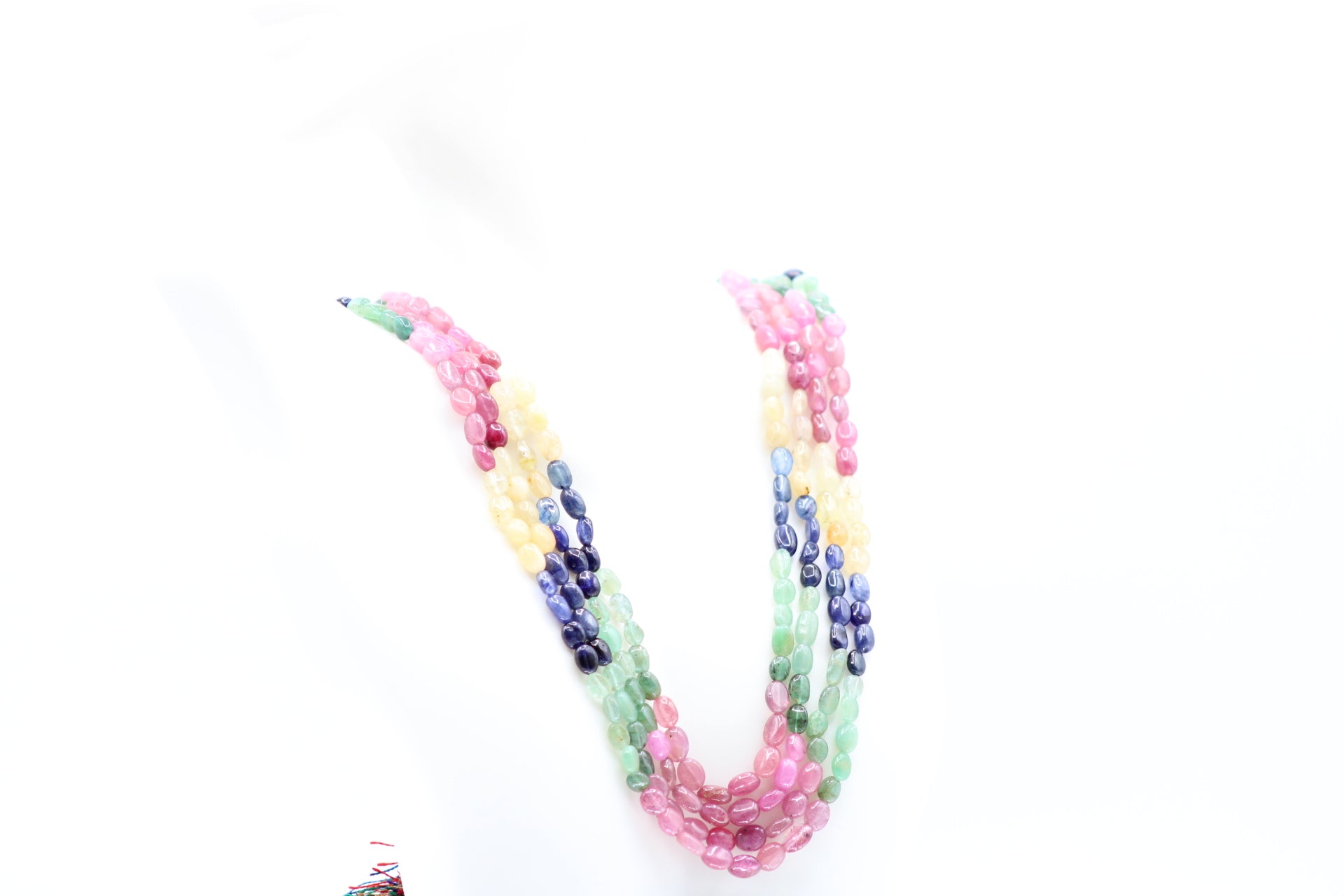 Multi Color Sapphire & Emerald Necklace featuring vibrant pink, blue, yellow, and green gemstones.