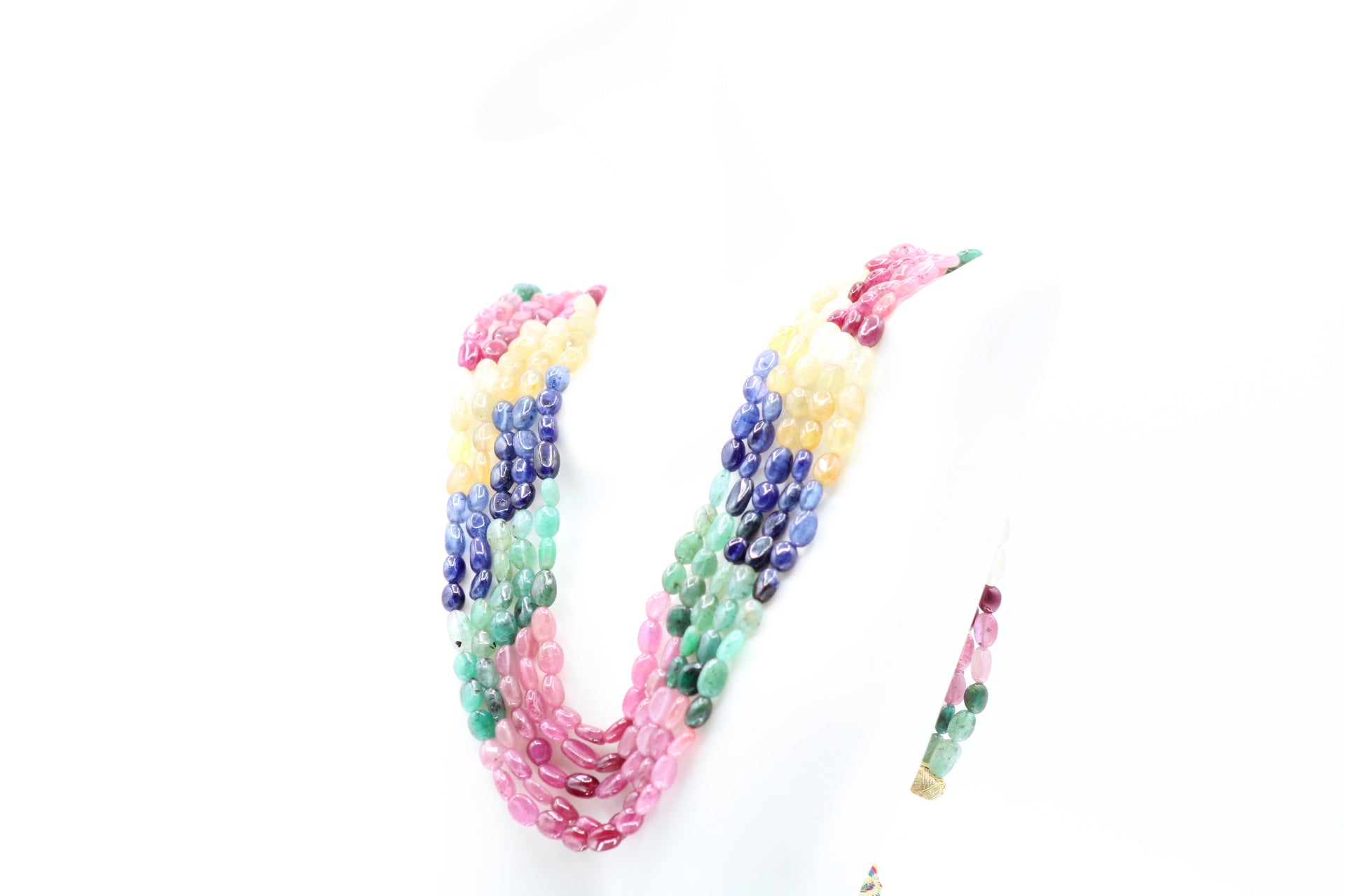 Multi Color Sapphire & Emerald Necklace displayed on a mannequin, showcasing vibrant hues of sapphires and emeralds.