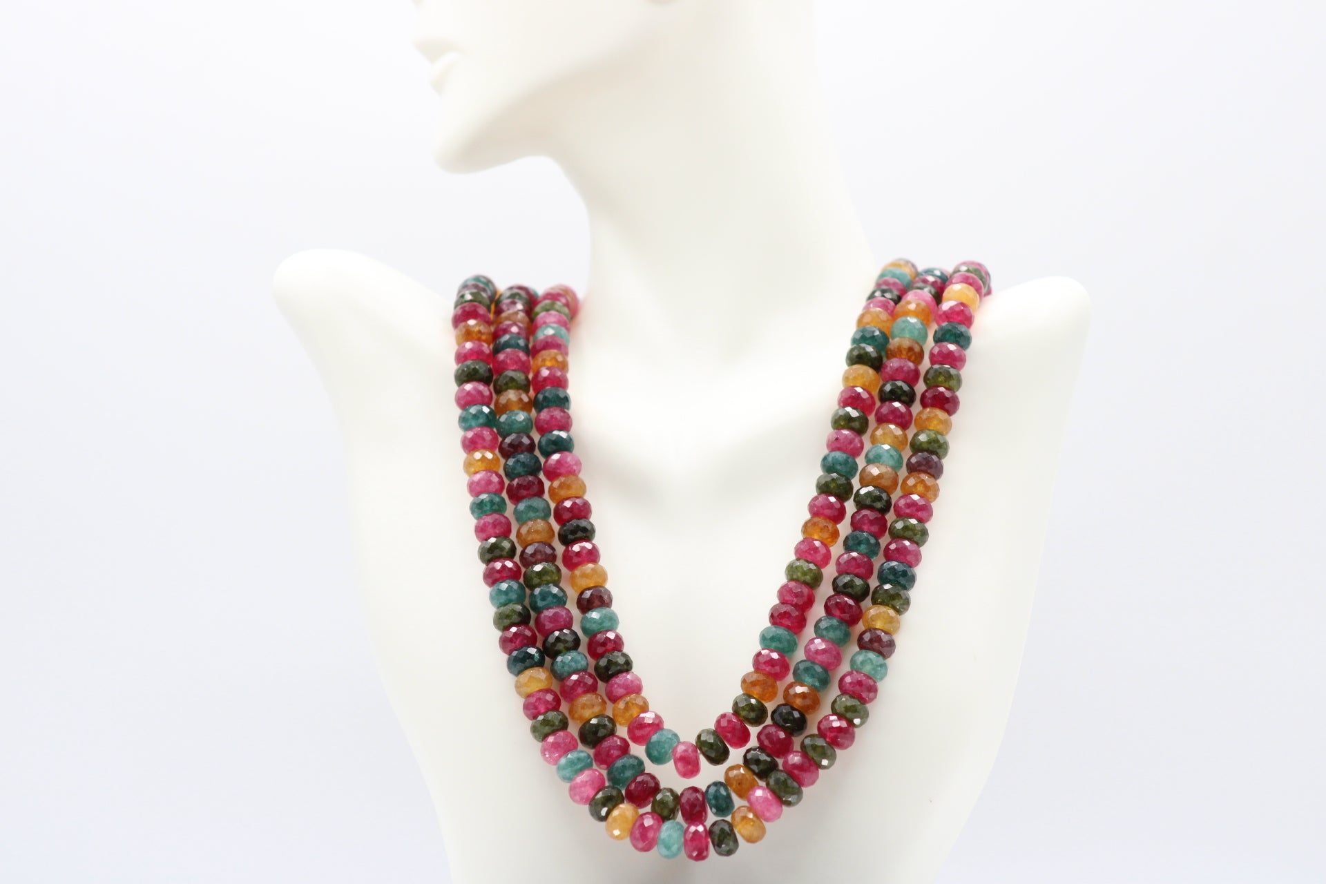 Multi-Color Jade Faceted Necklace with vibrant gemstones in yellow, blue, red, and green hues on a display bust.