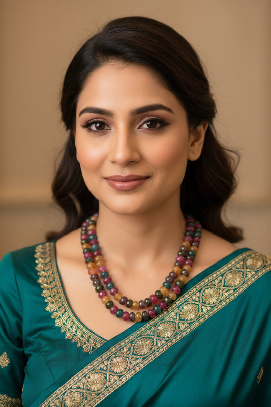 Multi Color Jade & Pearl Necklace worn by a woman in a teal outfit with intricate gold detailing.