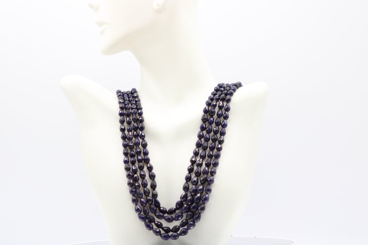The Blue Sapphire Briolette Pearl Shaped Necklace displayed on a mannequin, showcasing its elegant design and deep blue color.