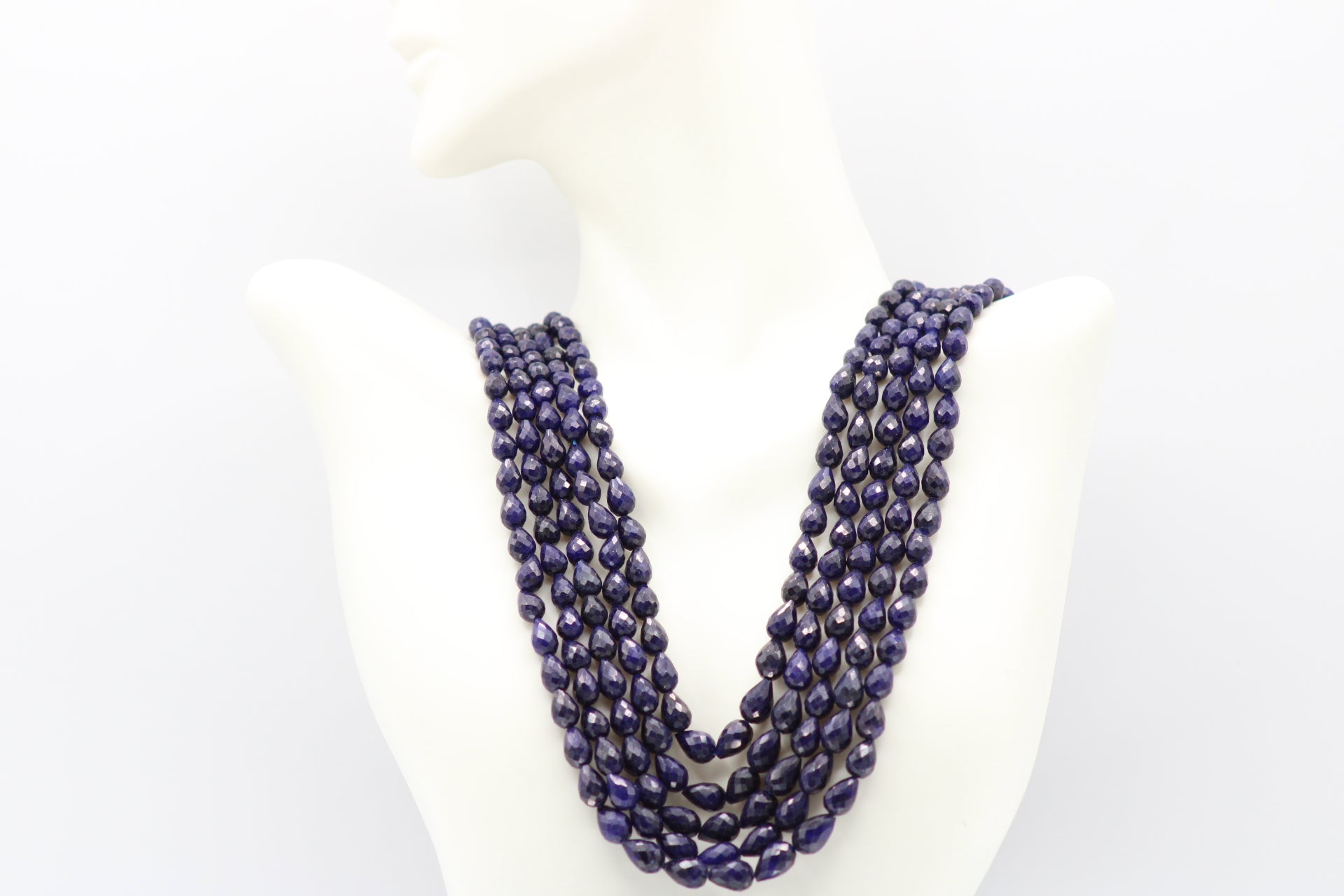 The Blue Sapphire Briolette Pearl Shaped Necklace displayed elegantly on a mannequin against a plain background.