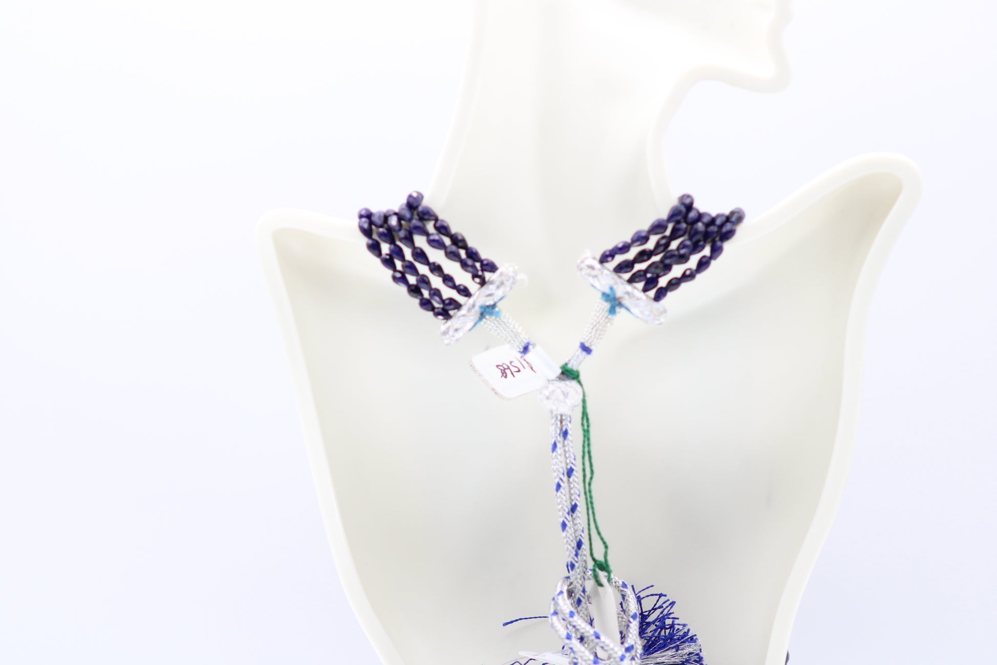 The Blue Sapphire Briolette Pearl Shaped Necklace displayed elegantly on a mannequin, showcasing its intricate design and deep blue hues.