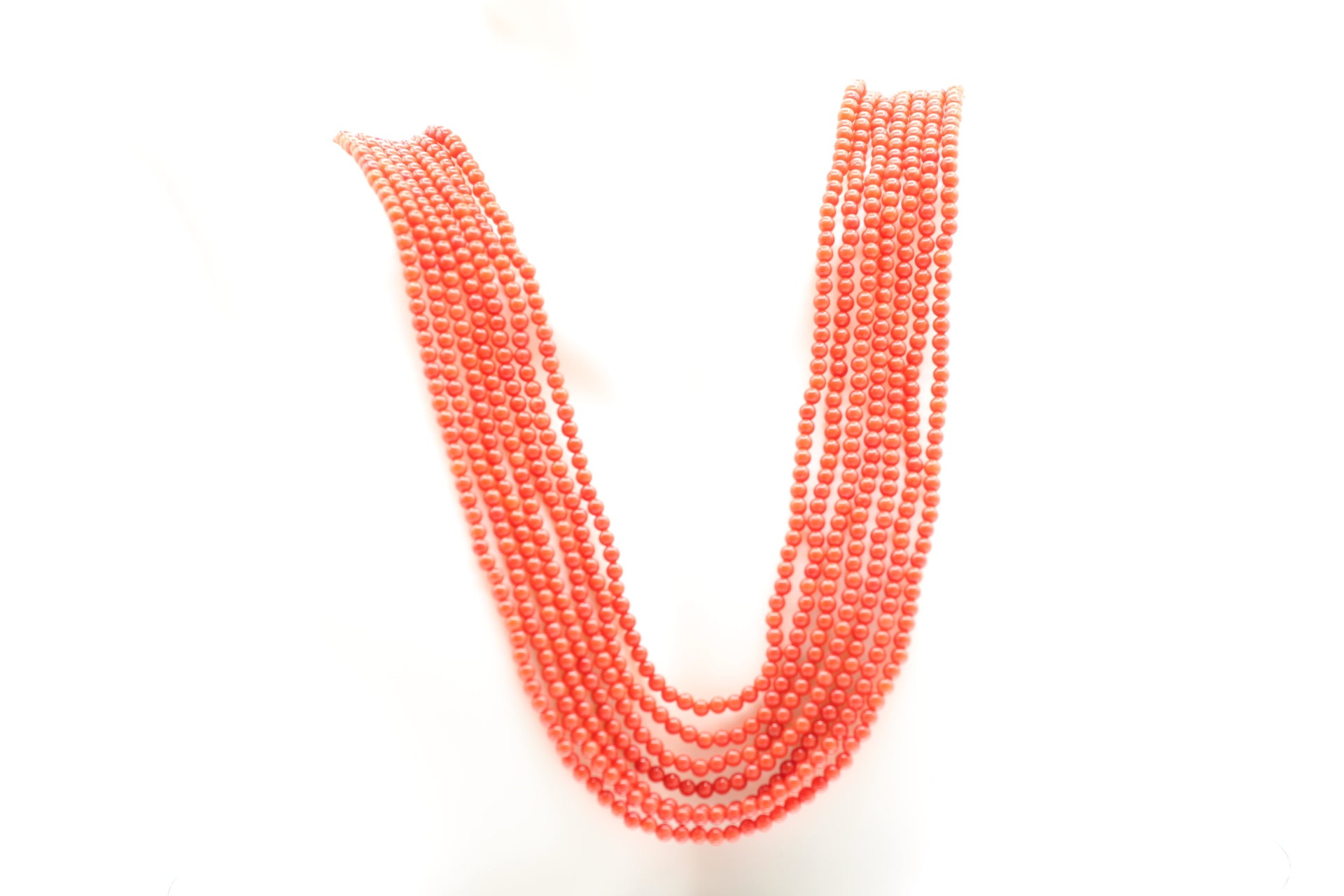 coral necklace 3mm round strands featuring 7 strands of polished reddish orange coral beads.