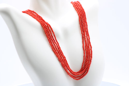 5 strand coral necklace featuring reddish orange gemstones layered elegantly on a display bust