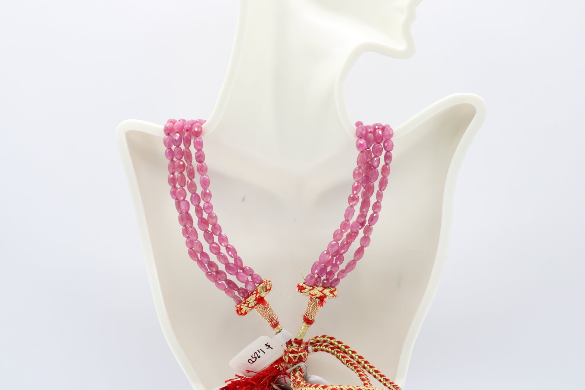 The Pink Sapphire Faceted Necklace displayed on a mannequin, showcasing radiant pink sapphires in elegant strands.