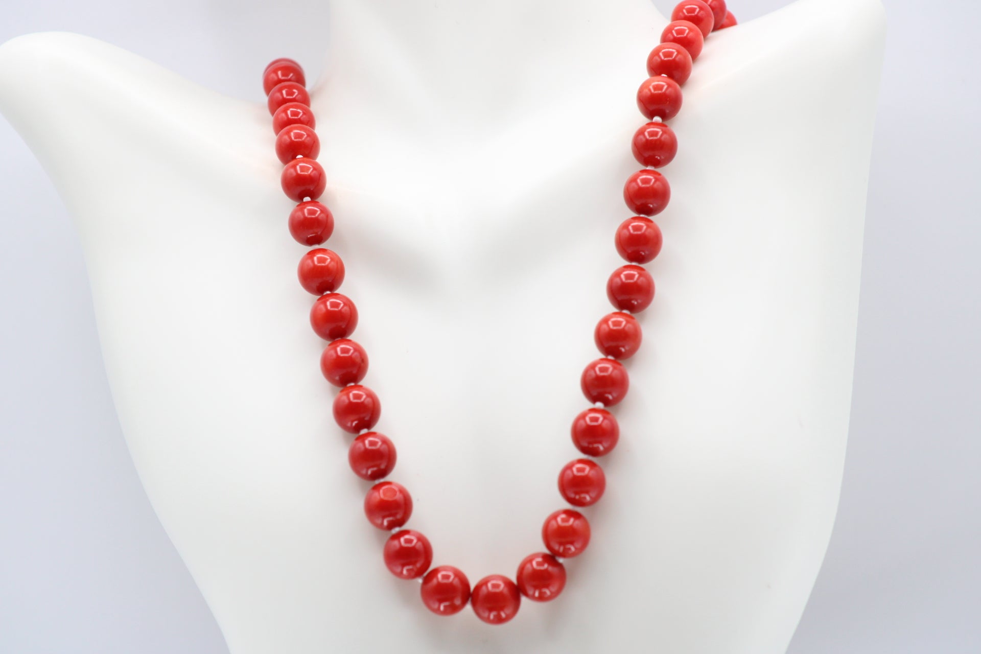 Natural orange coral gemstone necklace 8-10mm displayed on a mannequin with multiple strands.