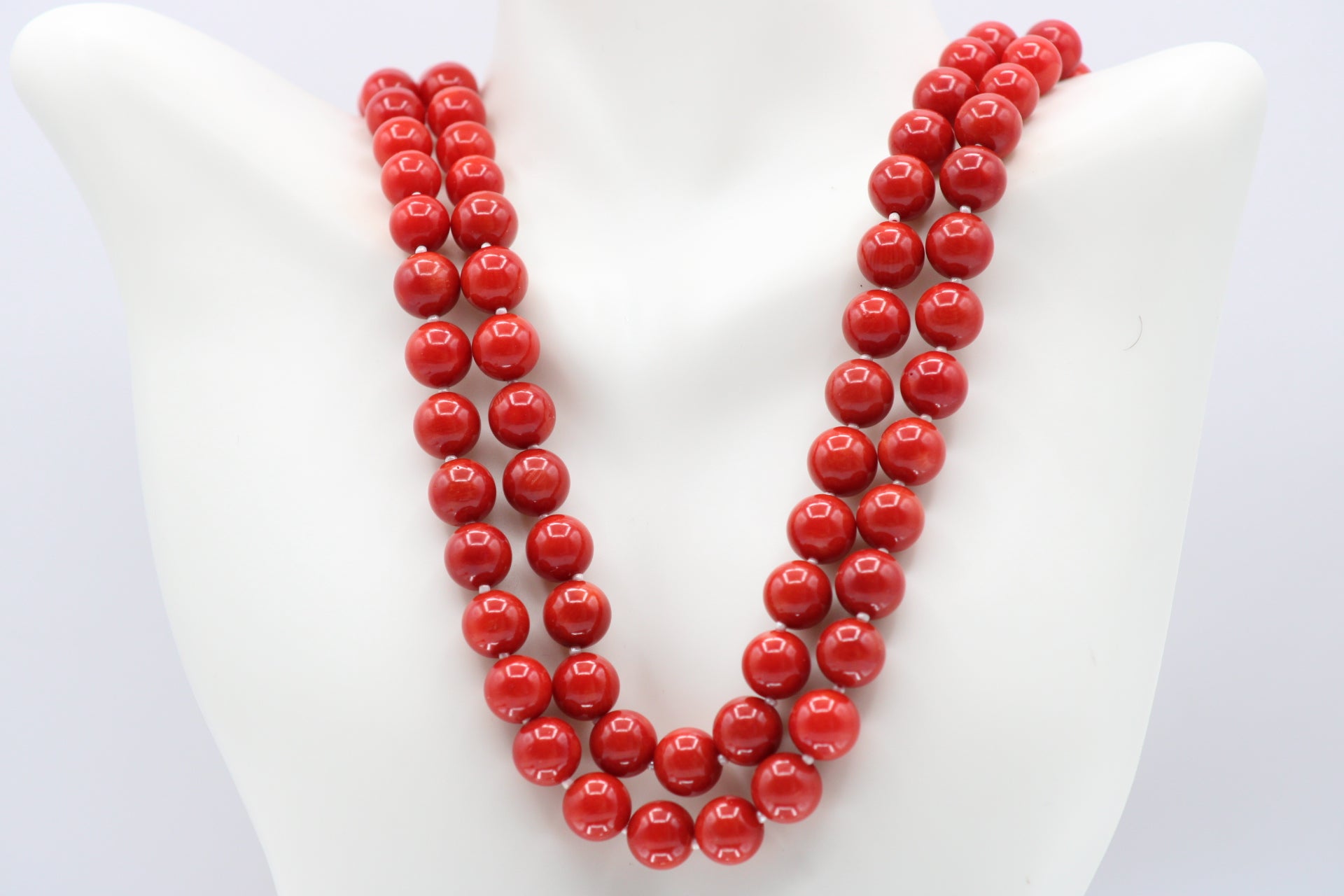 Natural orange coral gemstone necklace displayed on mannequin with multiple strands of 8-10mm beads.