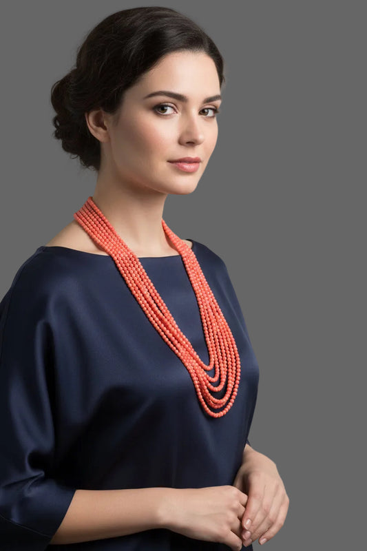 Coral Necklace 3mm - 7 Strands displayed on a bust, featuring multiple polished strands of reddish orange coral beads.