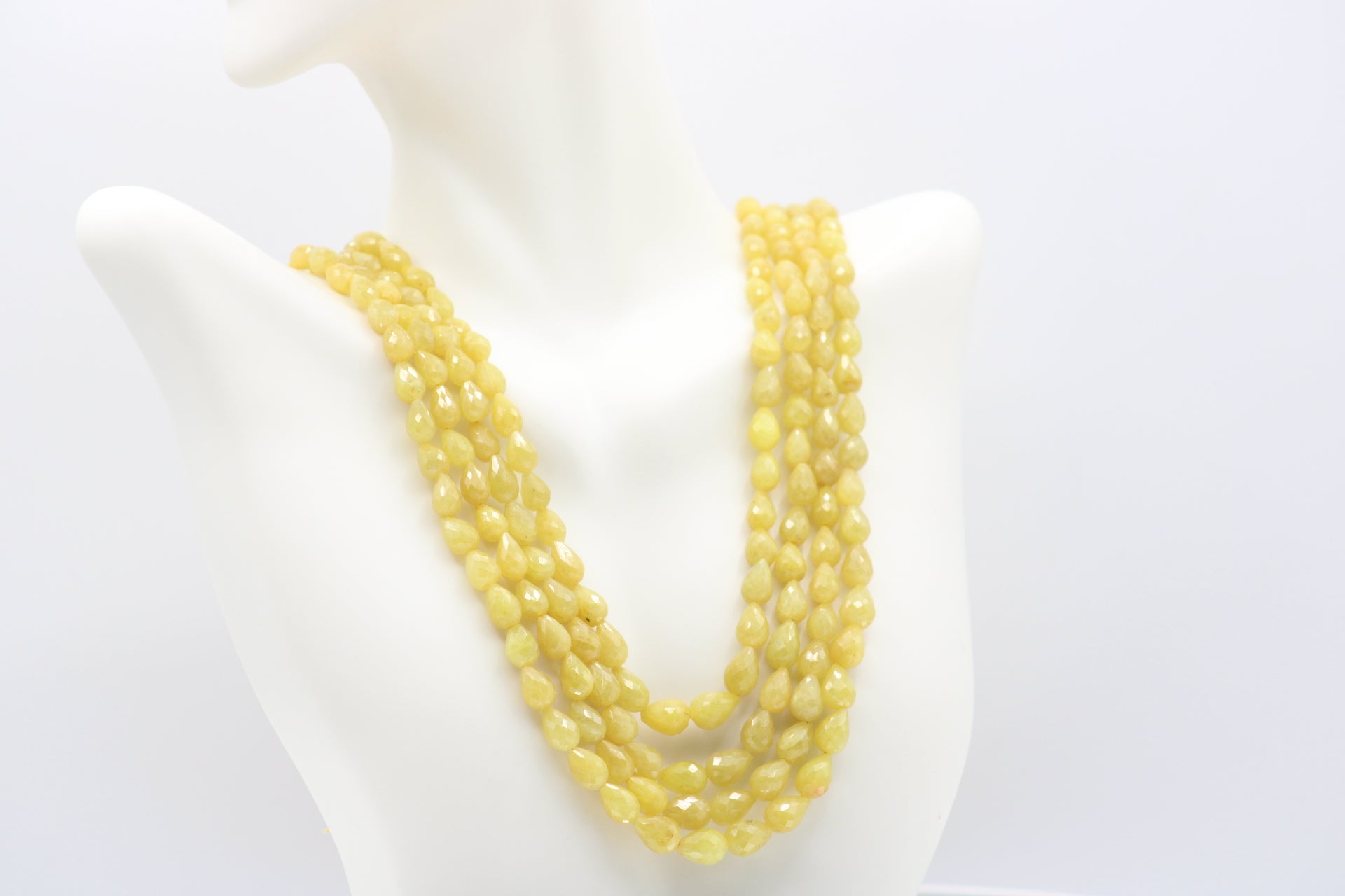 The Yellow Sapphire Briolette Pearl Shaped Necklace displayed on a mannequin.