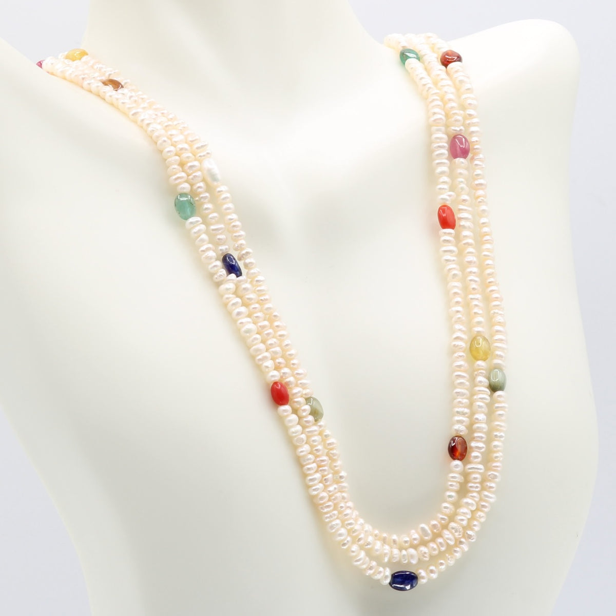 Fresh Water Pearl with colorful Navratna beads necklace displayed on a mannequin, symbolizing purity and elegance.