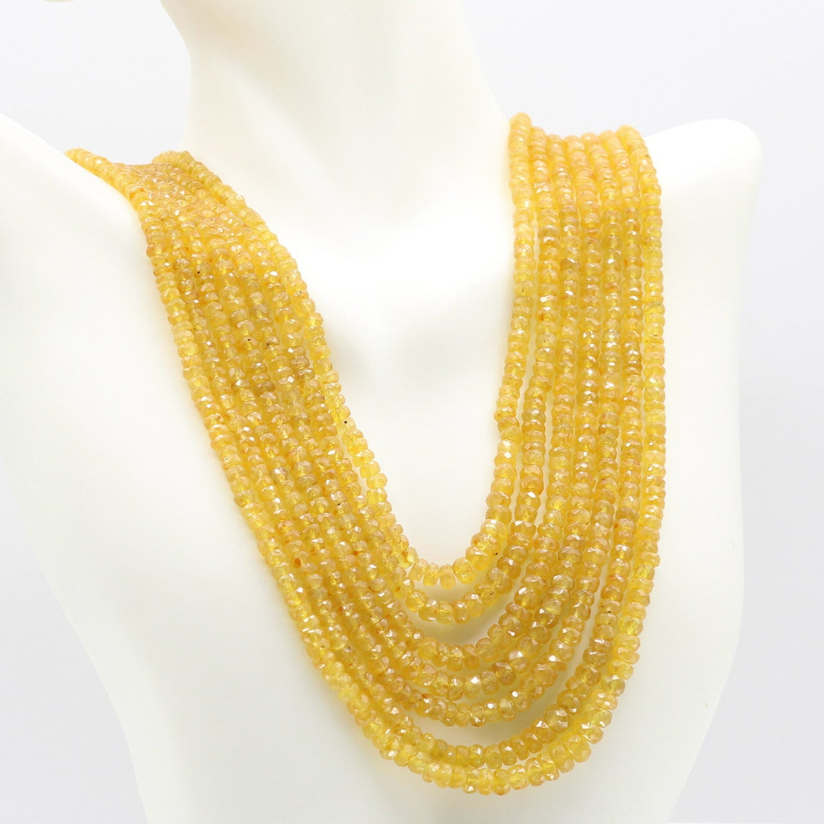 Yellow Sapphire Faceted Necklace displayed on a mannequin, showcasing multiple strands of vibrant yellow sapphires.