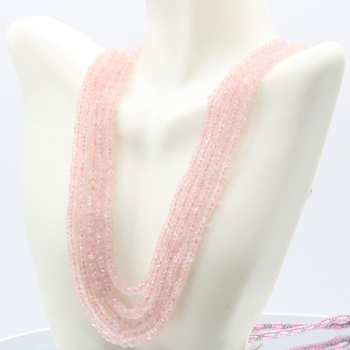 Morganite faceted necklace displayed on a mannequin, showcasing its beautiful pink hue.