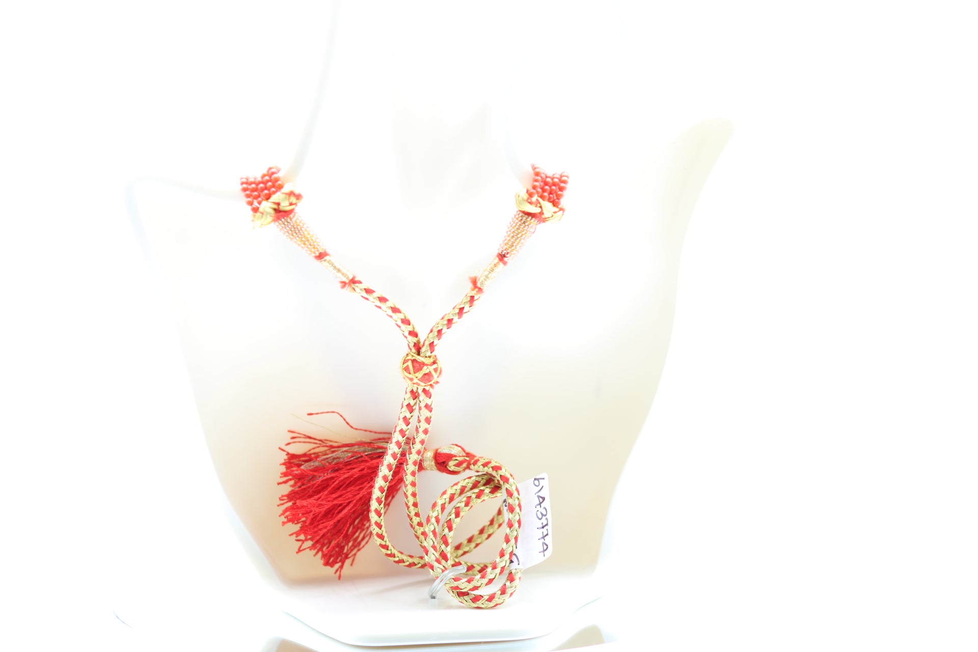 5 strand coral necklace featuring reddish orange coral gemstones on a decorative display.