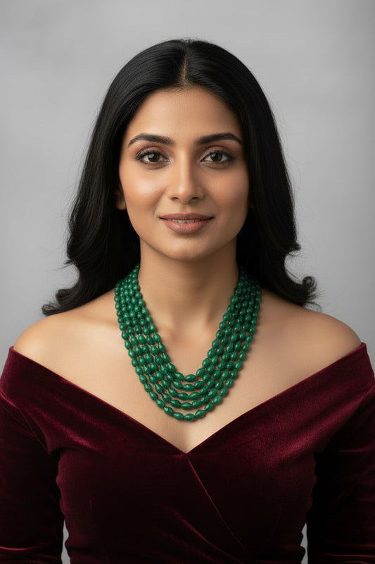 The Dark Green Sapphire Briolette Pearl Shaped Necklace showcased on a model wearing a light green outfit.
