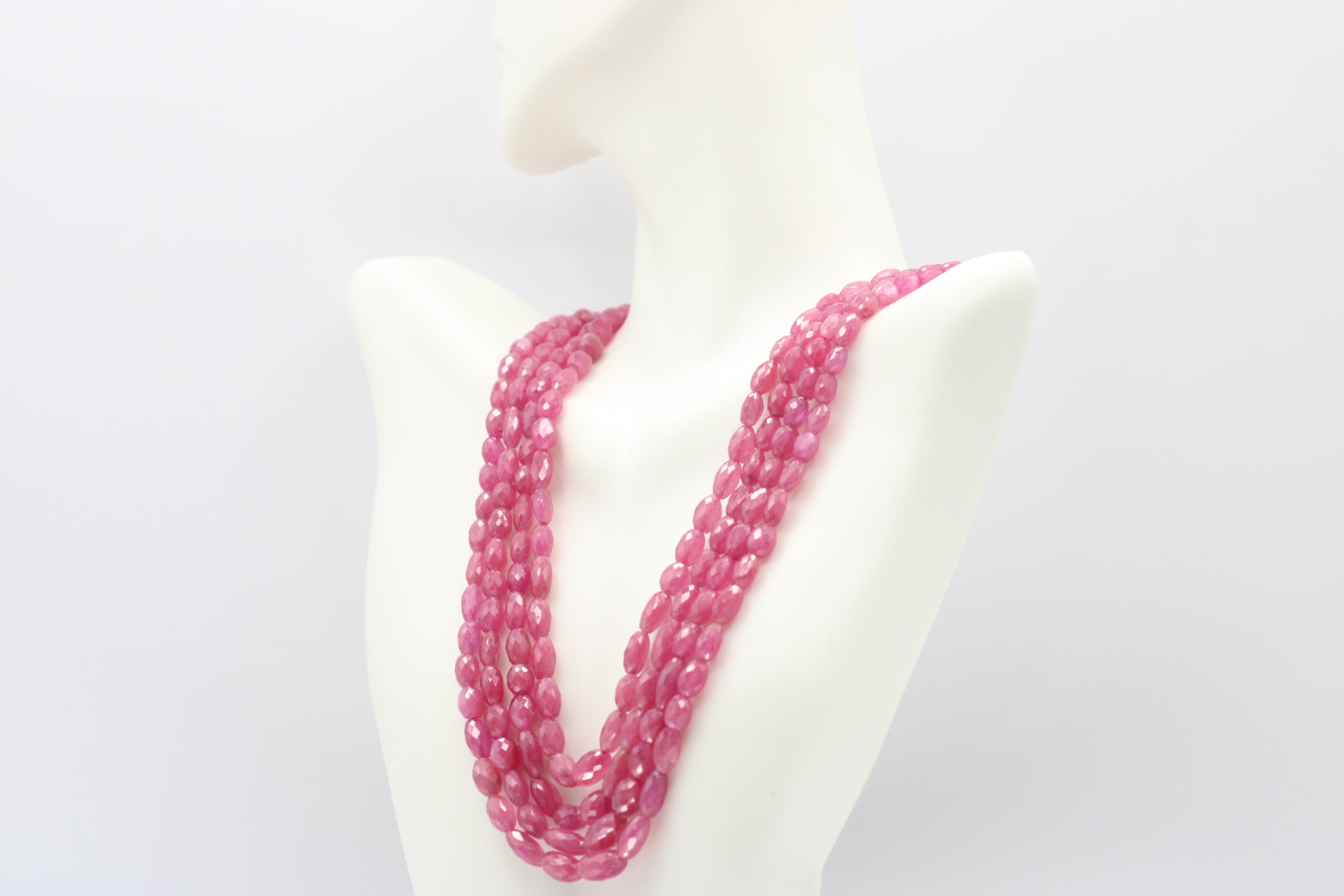 The Pink Sapphire Faceted Necklace displayed elegantly on a mannequin, showcasing its stunning pink sapphires.