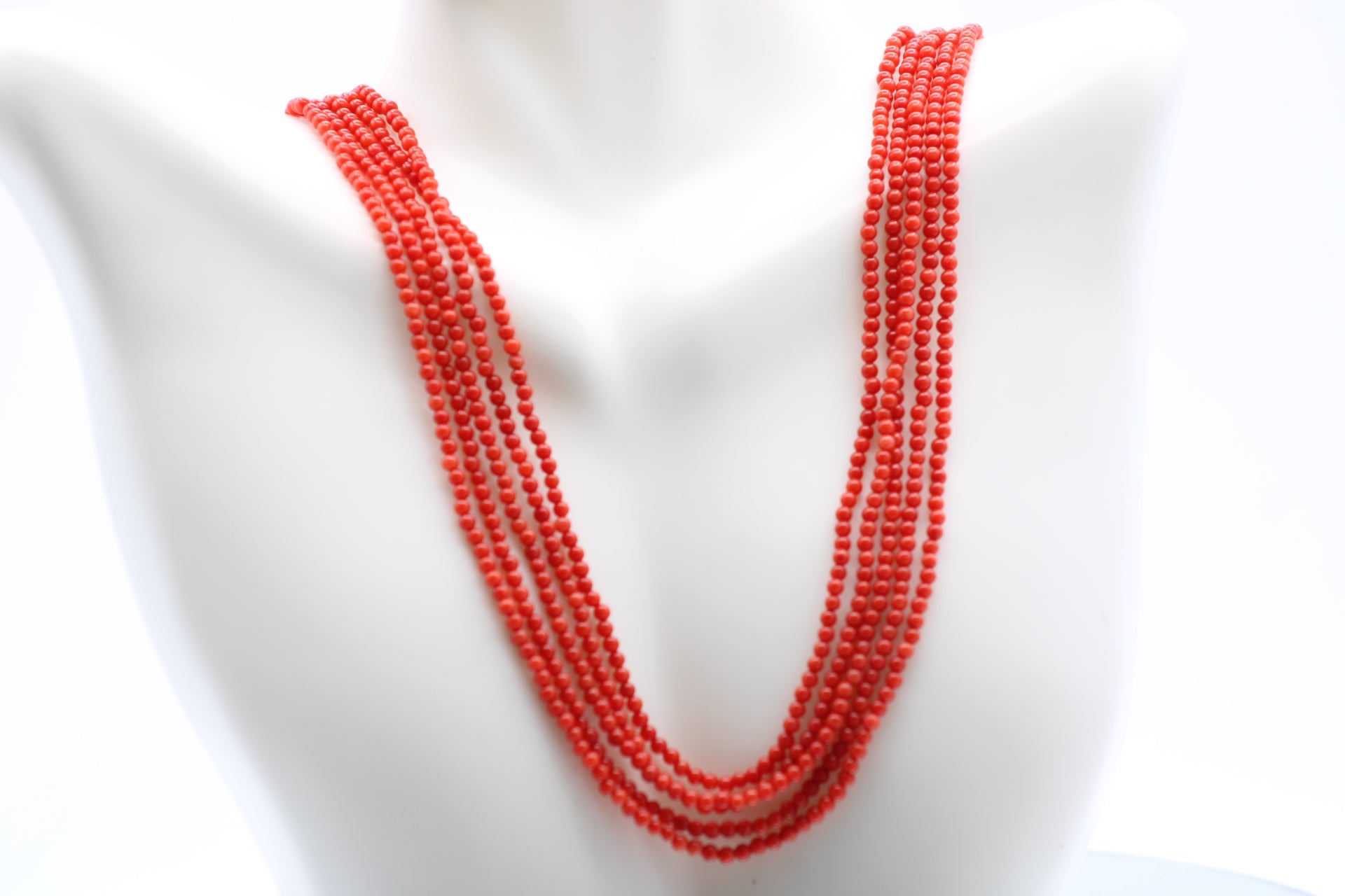 5 strand coral necklace featuring 2mm round reddish orange coral beads, showcasing elegant layers.