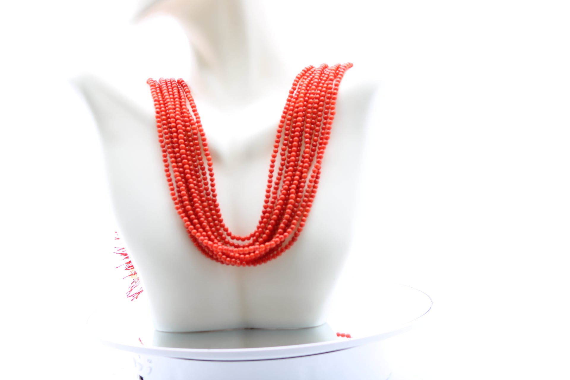 Coral Necklace 3mm - 10 Strands displayed on a mannequin with layered strands of reddish orange coral beads.