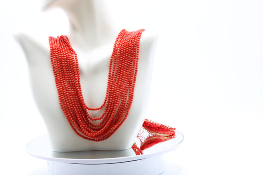 Coral Necklace 3mm - 10 Strands displayed on a mannequin, showcasing its vibrant reddish-orange color and polished finish.