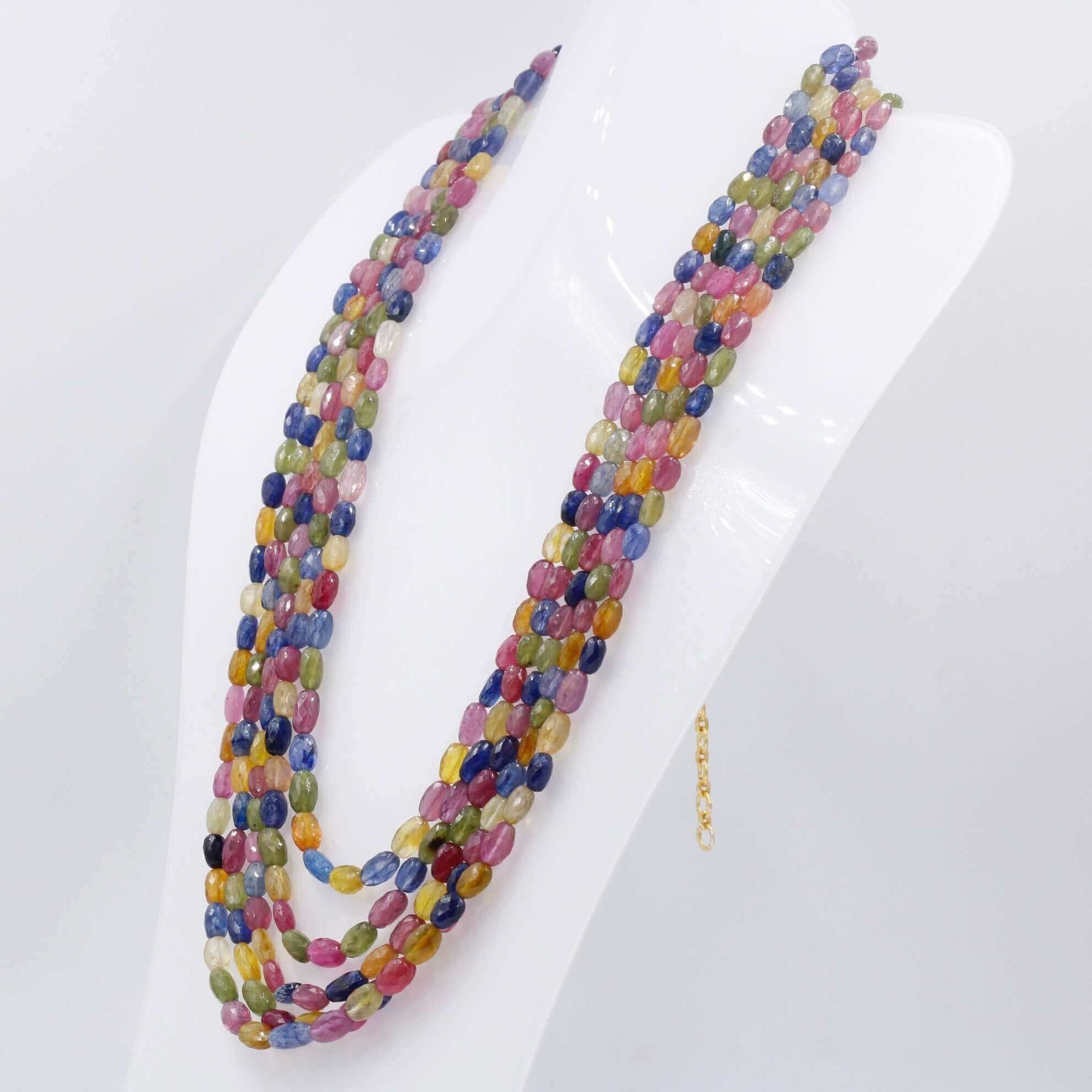 Multicolor sapphire ruby necklace displayed on a mannequin with vibrant gemstones.
