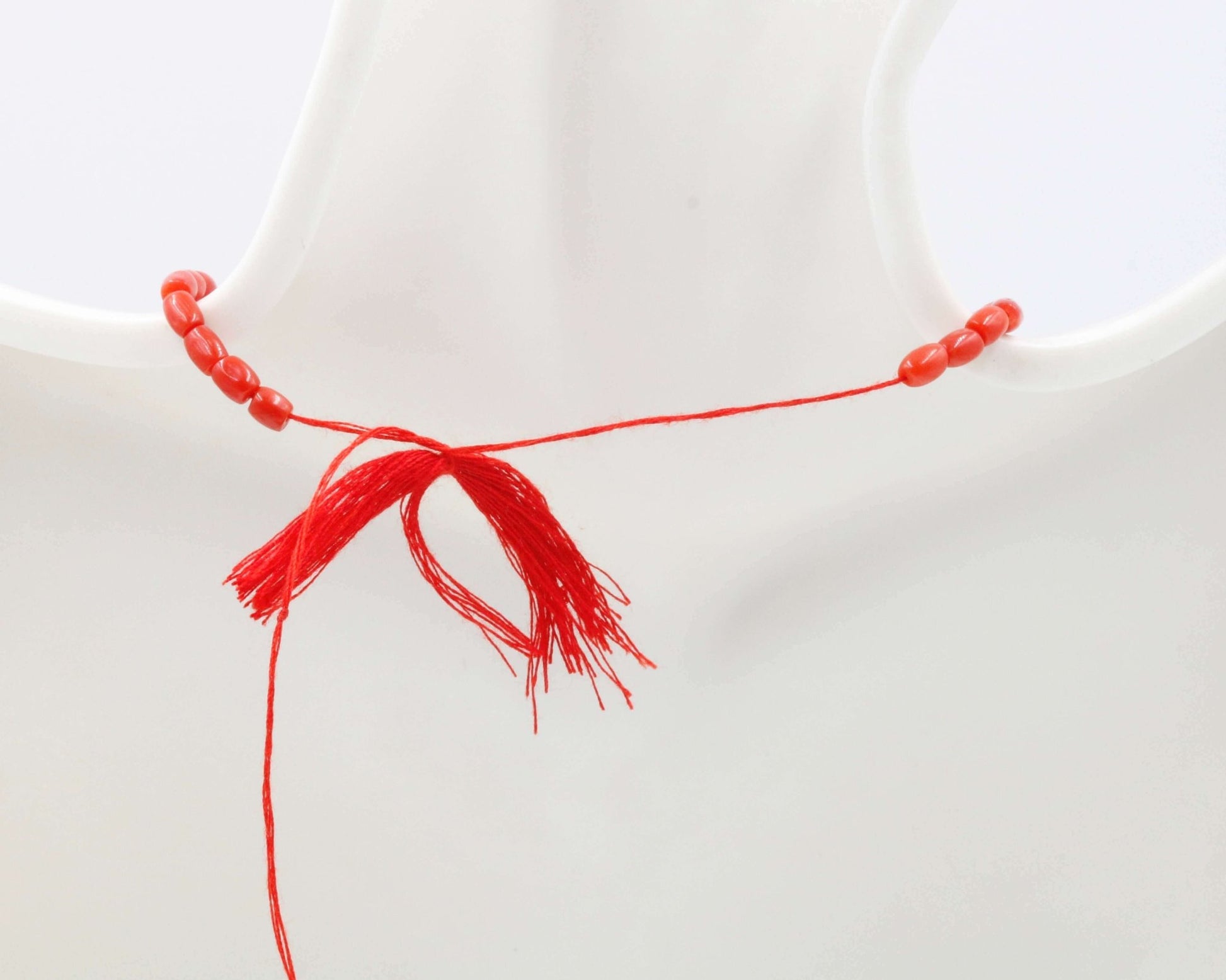 Italian Red Coral Beads Strands with a decorative red tassel, showcasing the beautiful red coral beads.