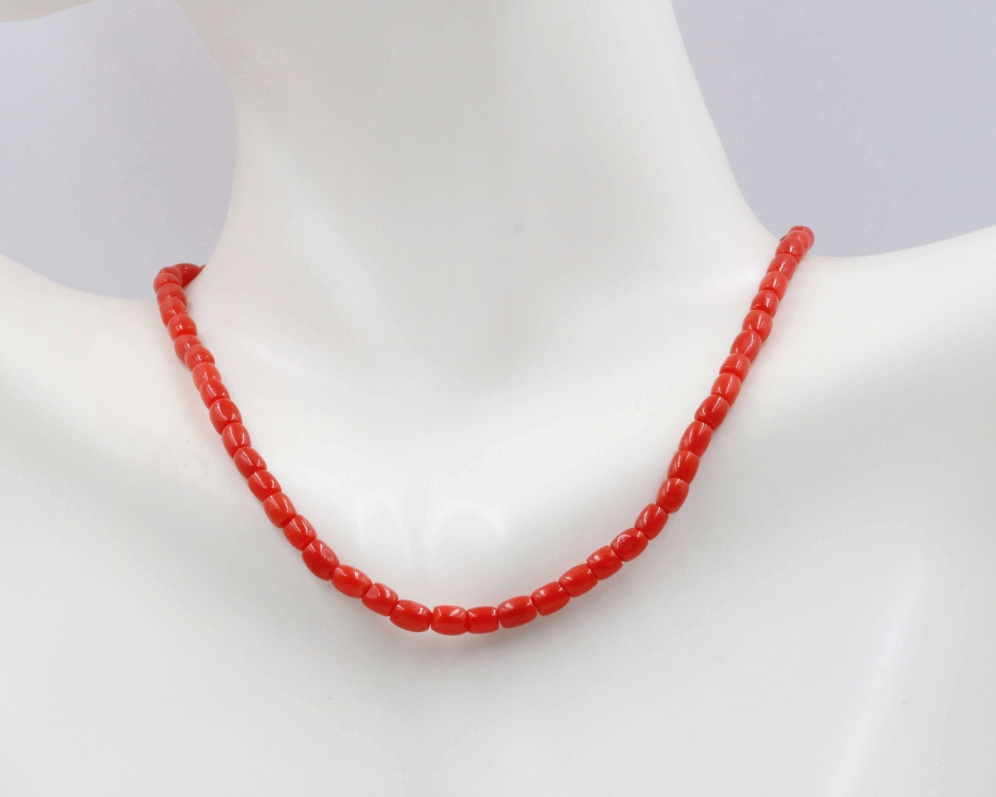 Italian Red Coral Beads Strands displayed on a mannequin necklace, showcasing vibrant red color and natural texture.